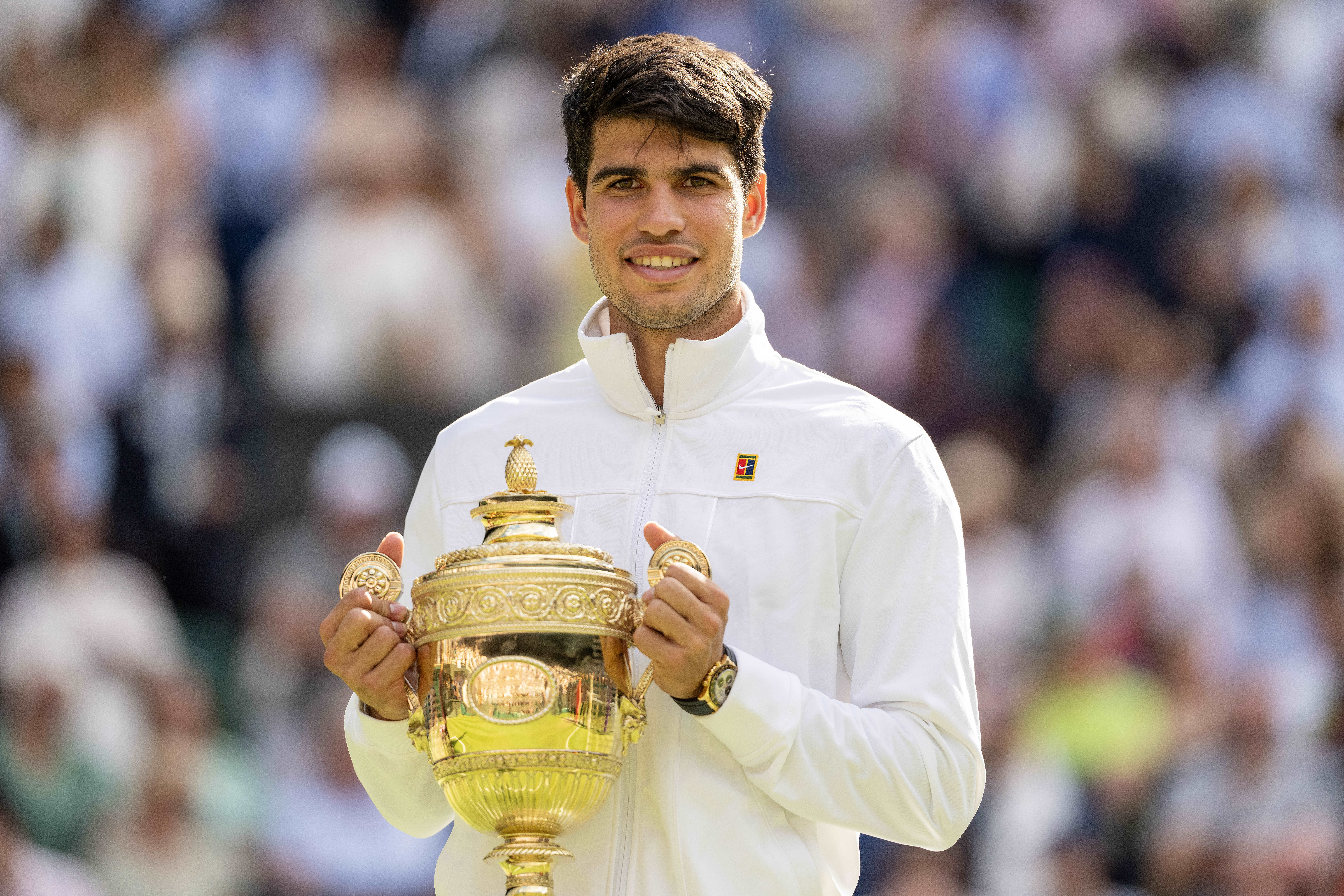 Jul 14, 2024; London, United Kingdom; Carlos Alcaraz of Spain poses with the trophy after winning the menÕs singles match against Novak Djokovic of Serbia on day 14 at All England Lawn Tennis and Croquet Club. Mandatory Credit: Susan Mullane-USA TODAY Sports