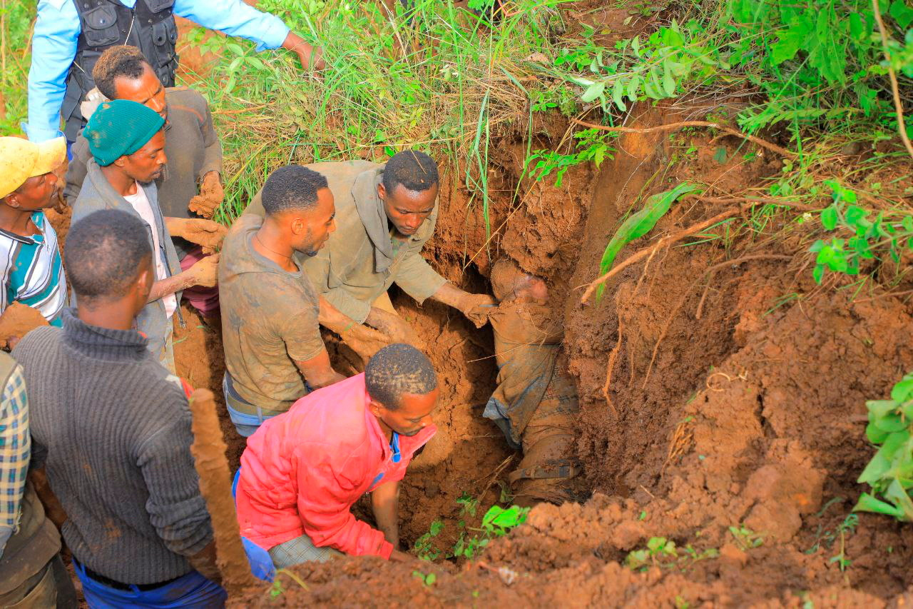 Residents dig to recover the dead body of a victim of the landslide following heavy rains that buried people in Gofa zone, Southern Ethiopia