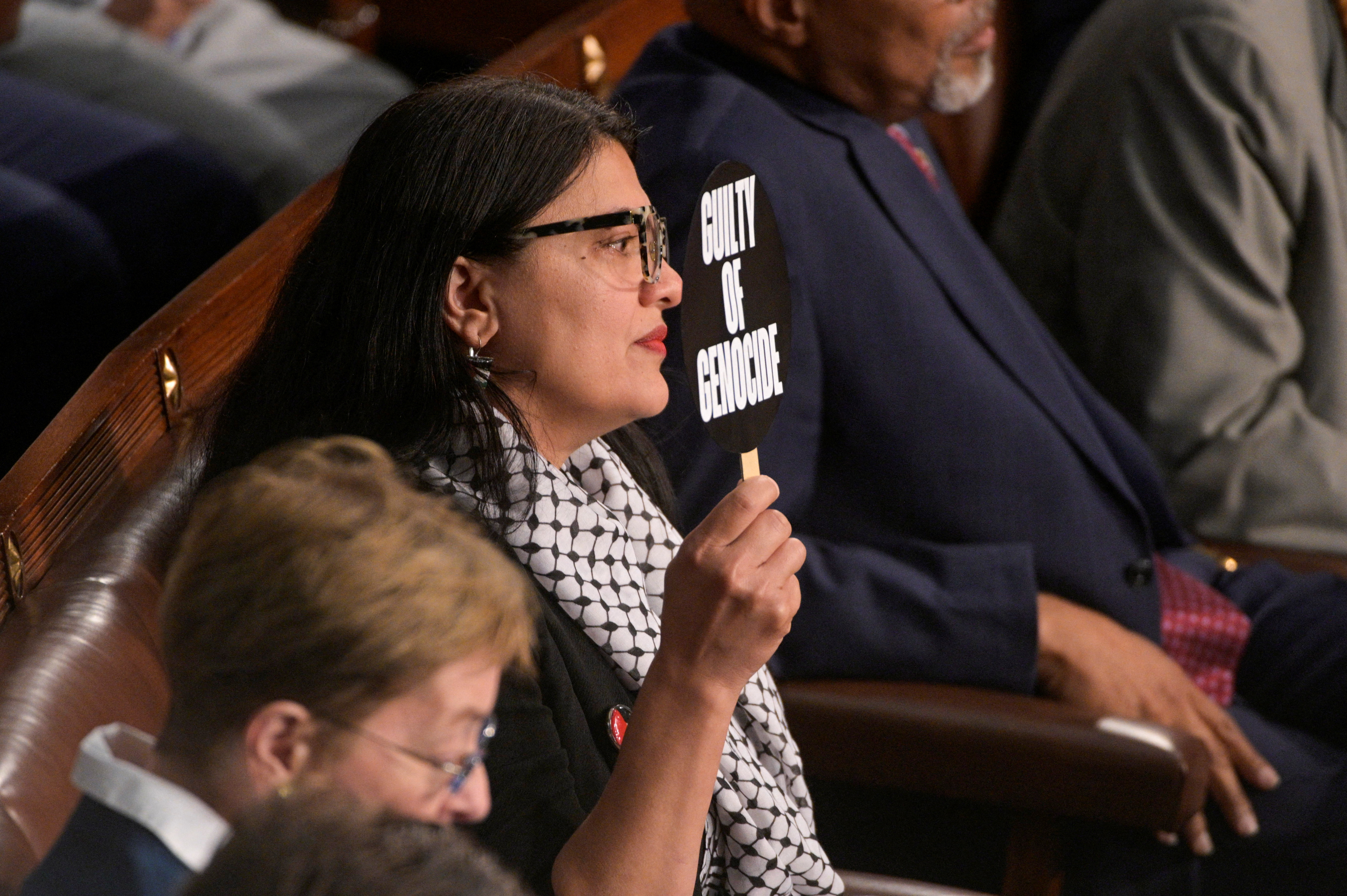 Rashida Tlaib holds up a sign in protest