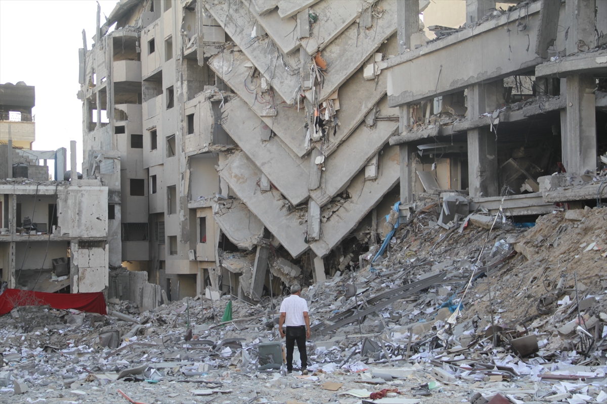 a man looks at a collapsed building