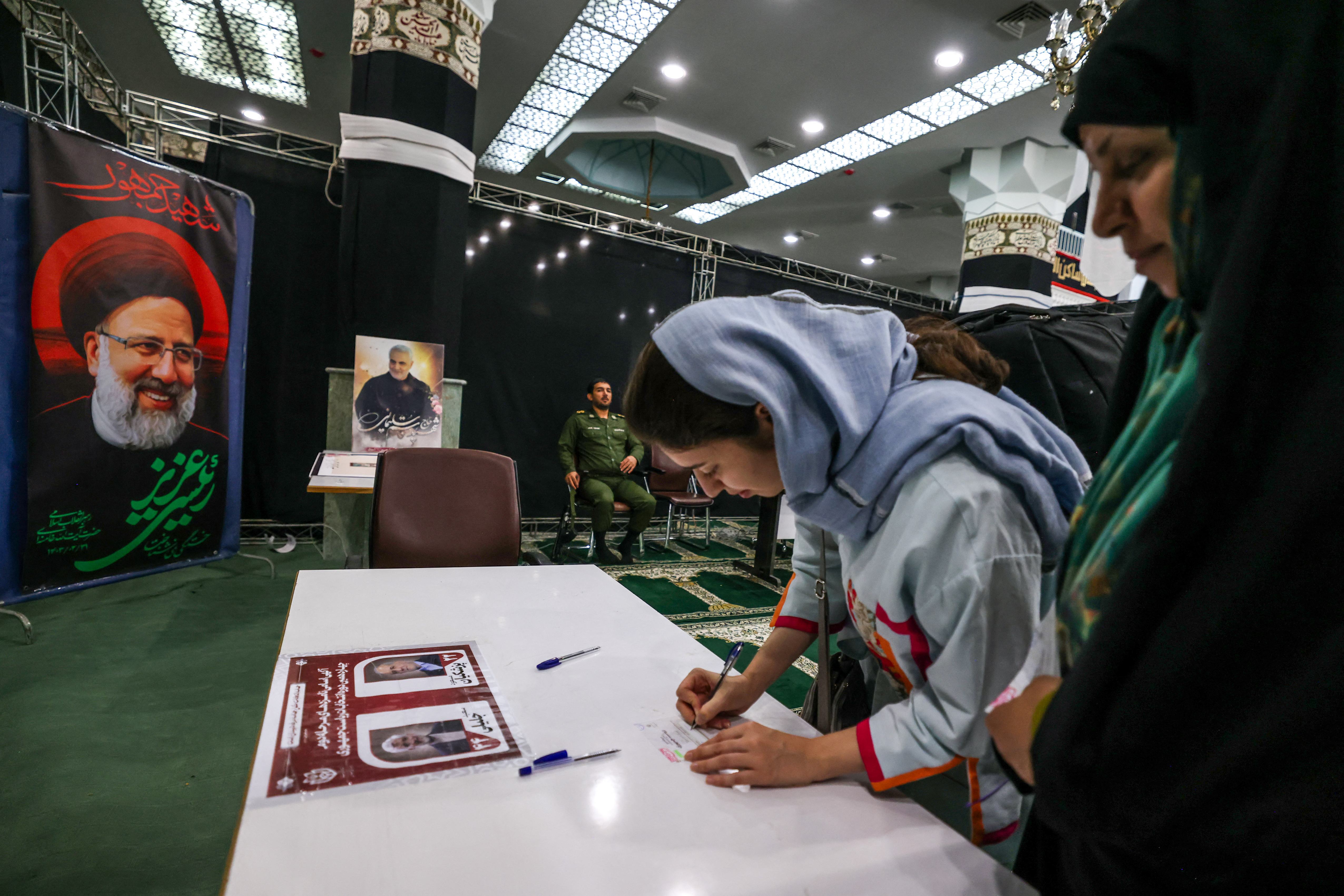 Iranian women prepare to cast their ballots at a polling station in Tehran on July 5, 2024. Polls opened on July 5 for Iran's runoff presidential election, the interior ministry said, pitting reformist candidate Masoud Pezeshkian against ultraconservative Saeed Jalili in the race to succeed Ebrahim Raisi, who died in a May helicopter crash. (Photo by ATTA KENARE / AFP)