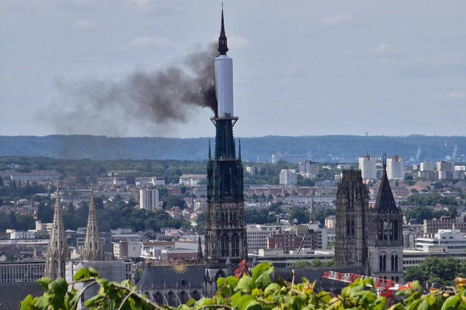 Smoke billows from the spire of Rouen Cathedral in Rouen, northern France on July 11, 2024. - Mayor of Rouen Nicolas Mayer-Rossignol said midday on X, that a fire was in progress on the cathedral showing a photograph of a plume of smoke escaping from scaffolding surrounding the spire. (Photo by Patrick STREIFF / AFP)