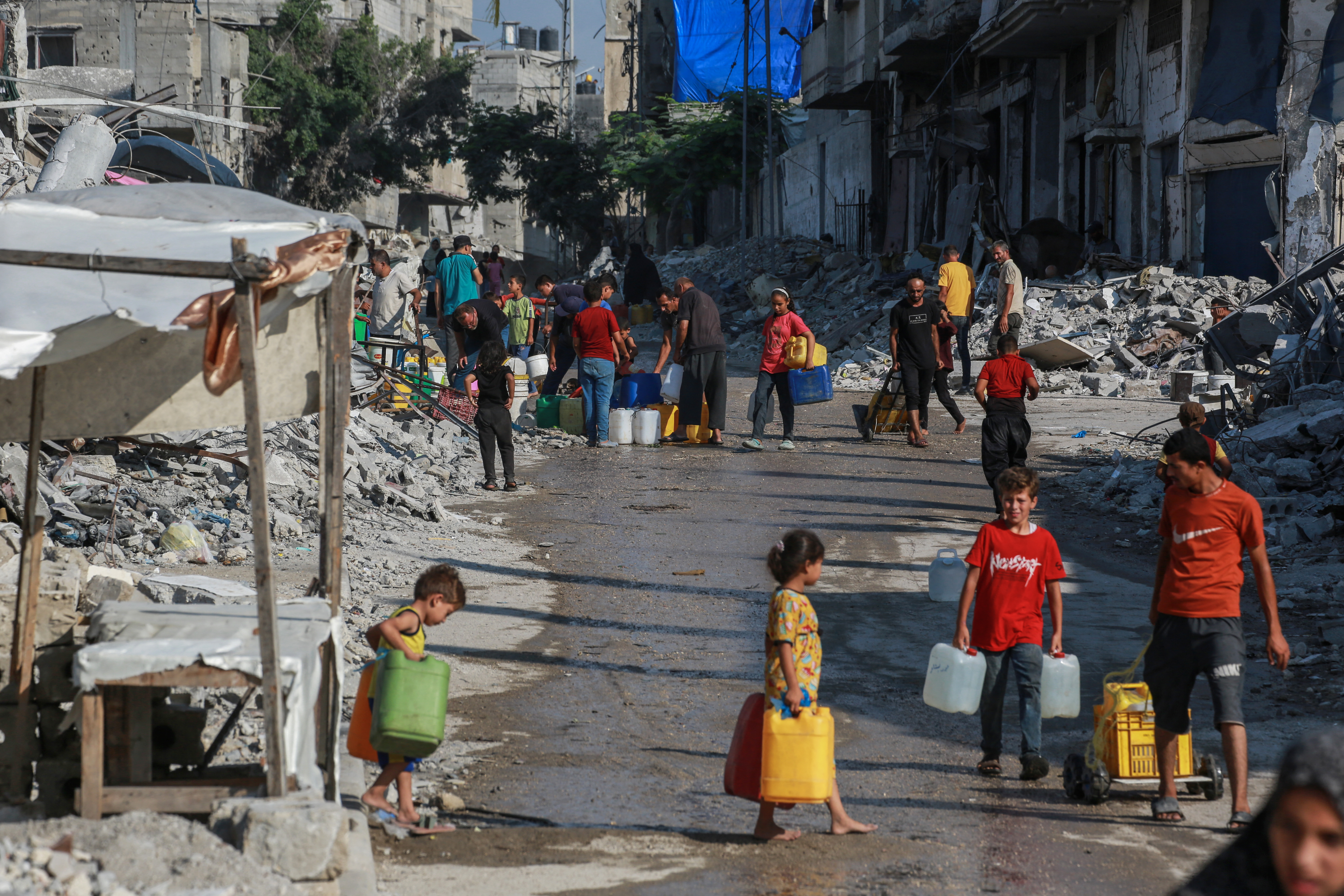 Palestinians queue to fill containers with water in Khan Yunis city in the southern Gaza Strip