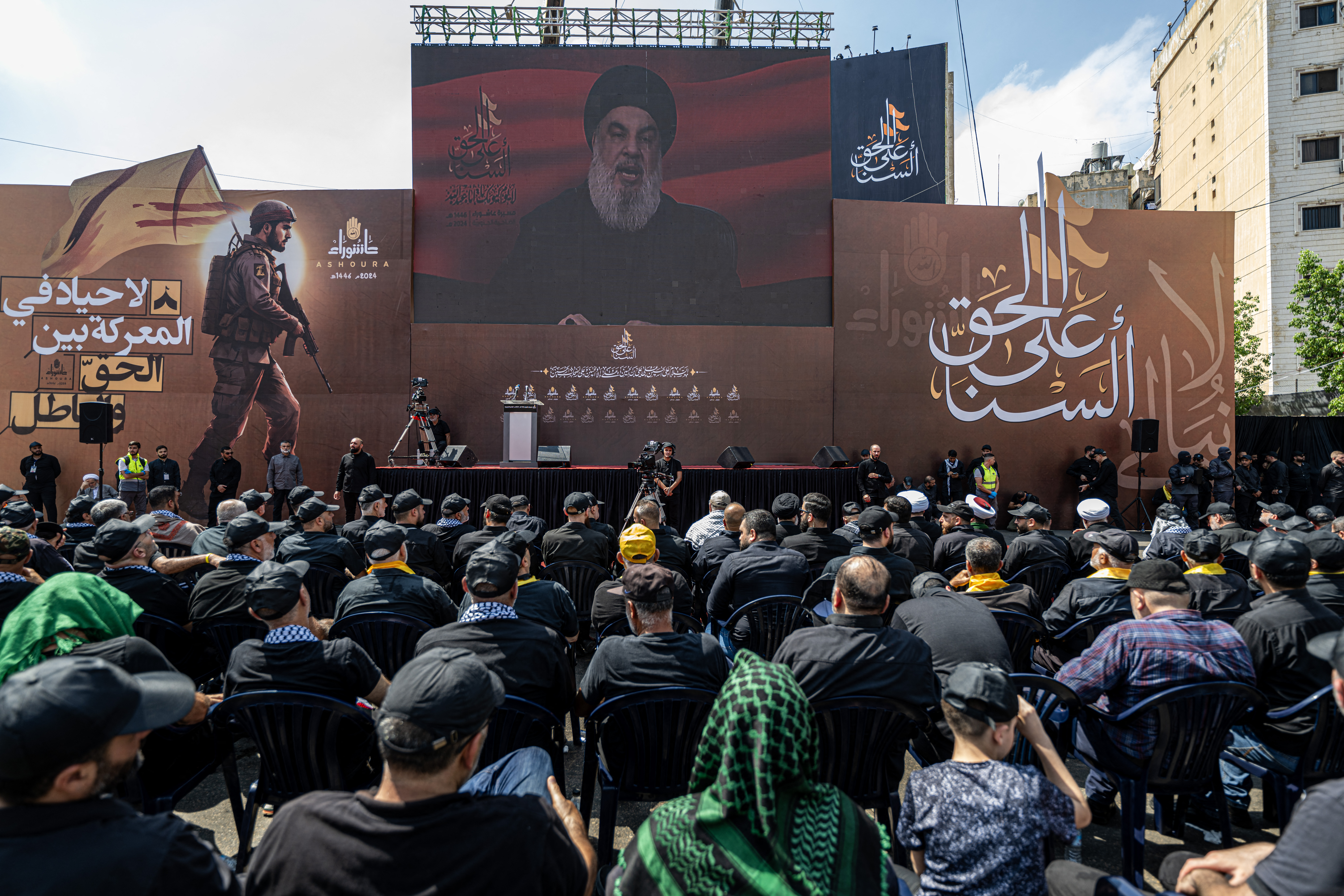 People watch a televised speech of Lebanon's Hezbollah chief Hasan Nasrallah following the march of Ashura, commemorating the 7th century killing of Prophet Muhammad's grandson Imam Hussein, in Beirut on July 17, 2024. - (Photo by Khaled DESOUKI / AFP)