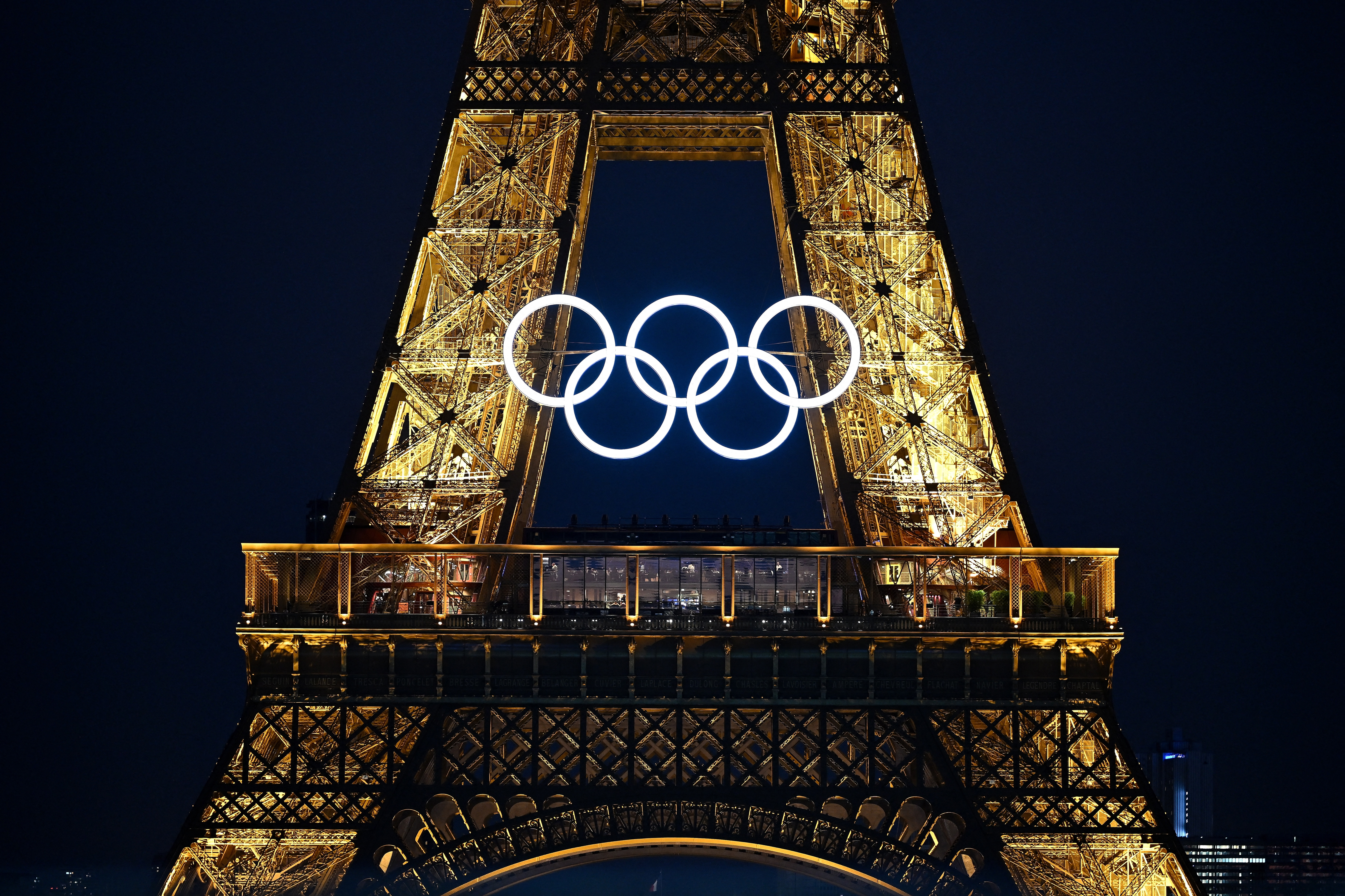 This photograph shows the Eiffel Tower bearing the Olympics rings, lit-up ahead of the Paris 2024 Olympic and Paralympic games, in Paris on July 20, 2024.