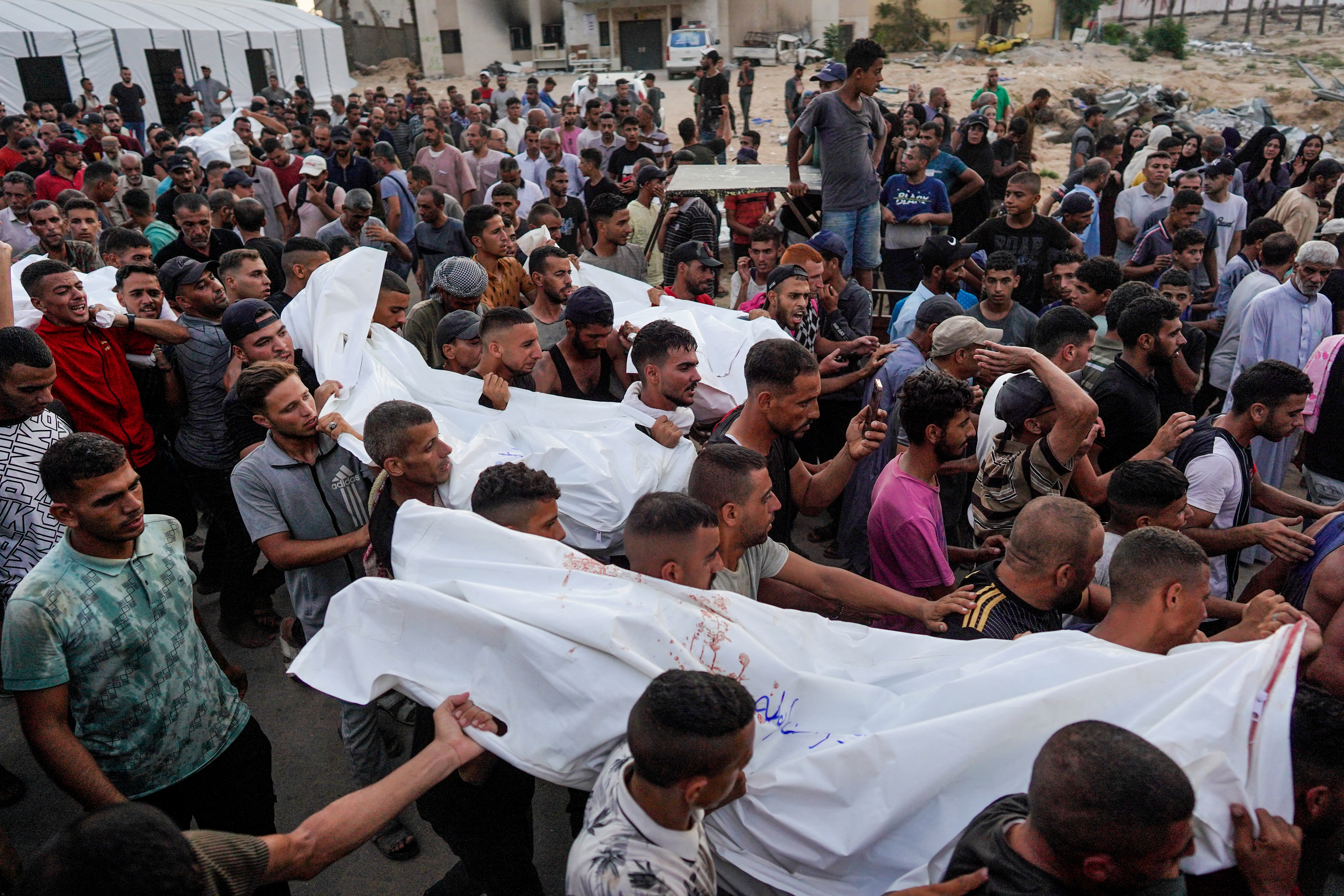 Palestinian mourners carry the bodies of family members of the Abu Taha family, outside Nasser hospital in Khan Yunis