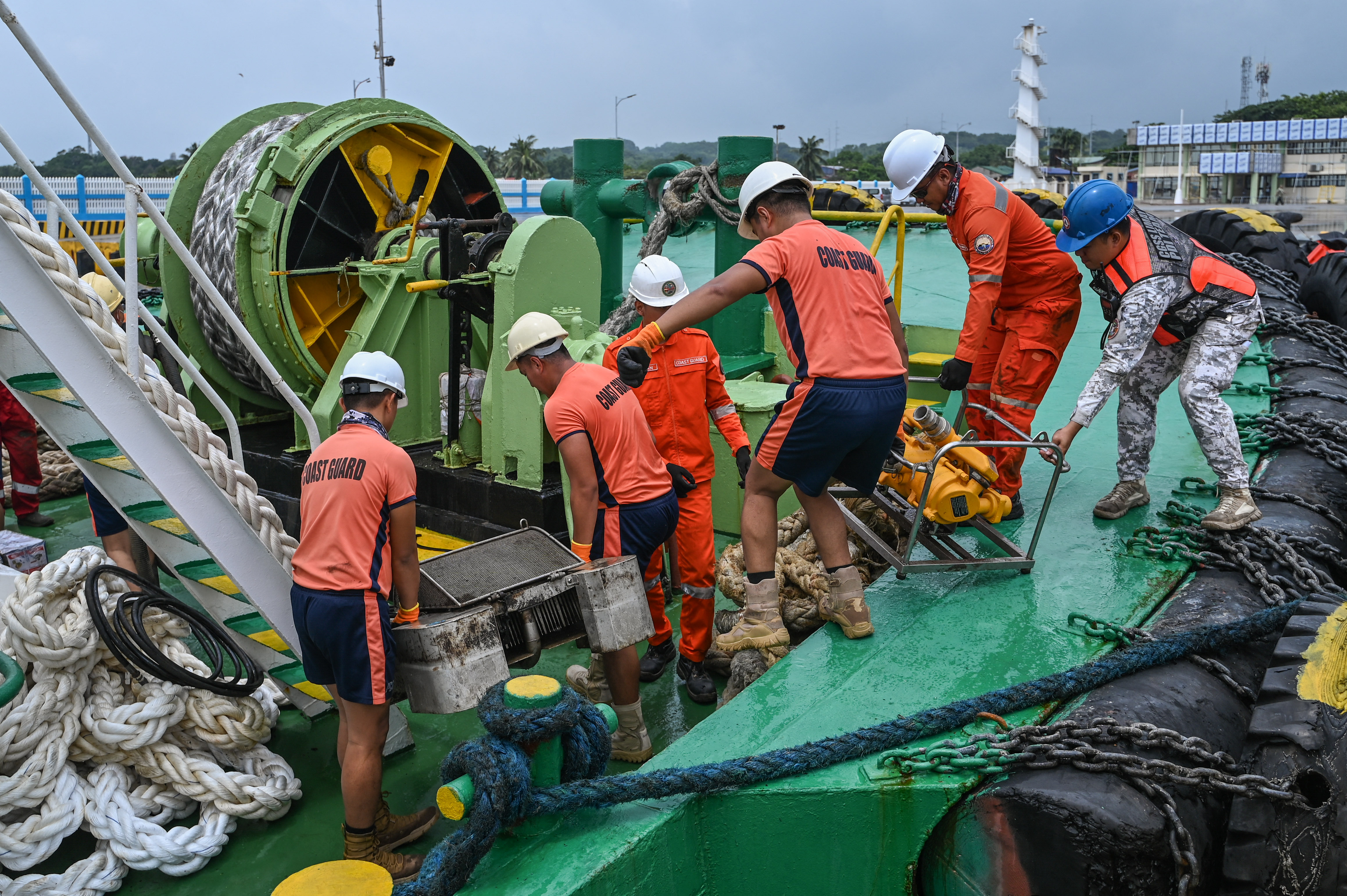 Coast guard personnel load the skimmers to be used in the oil spill response, at a port in Limay, Bataan
