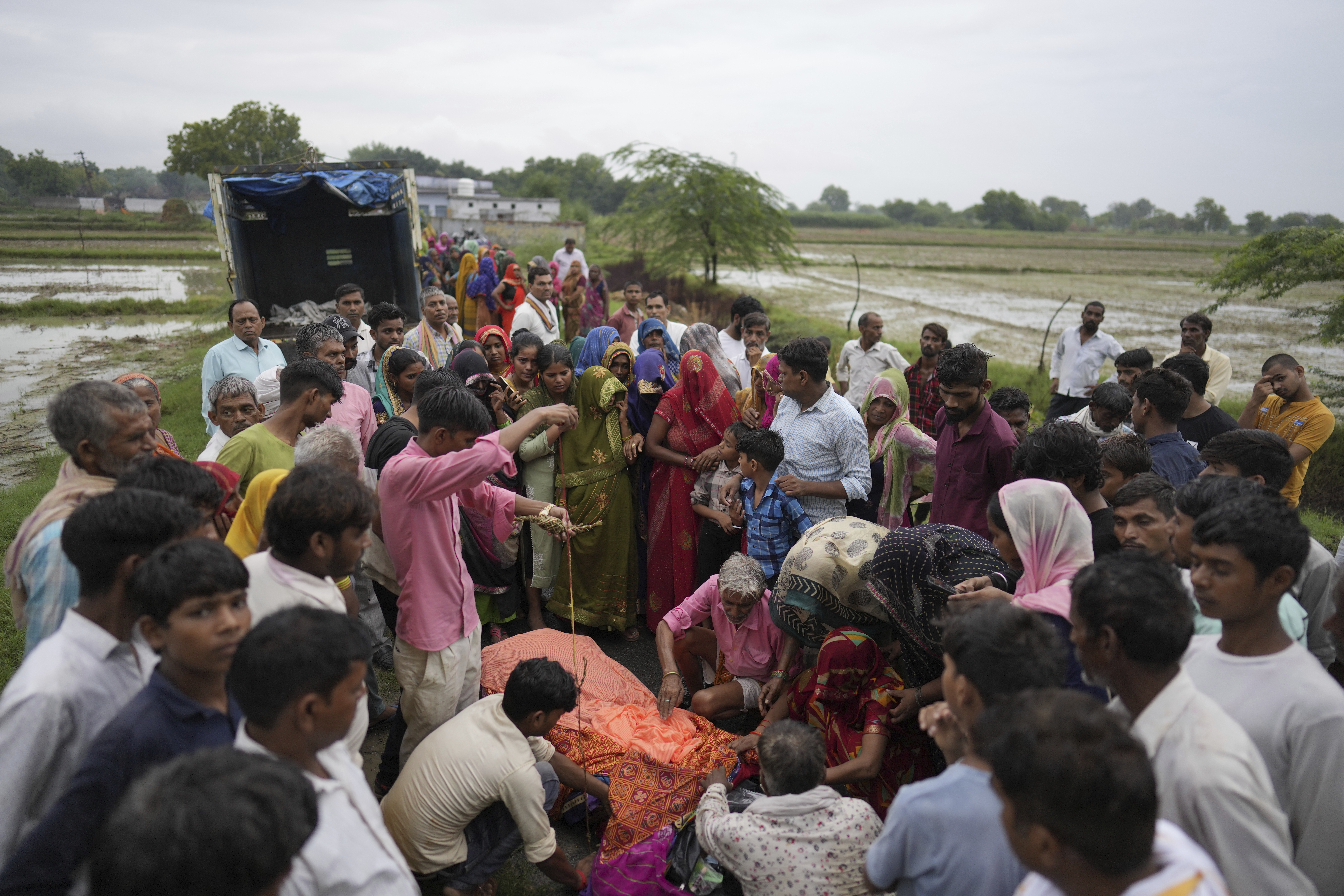 Family members and neighbors perform the last rites of Savitri Devi