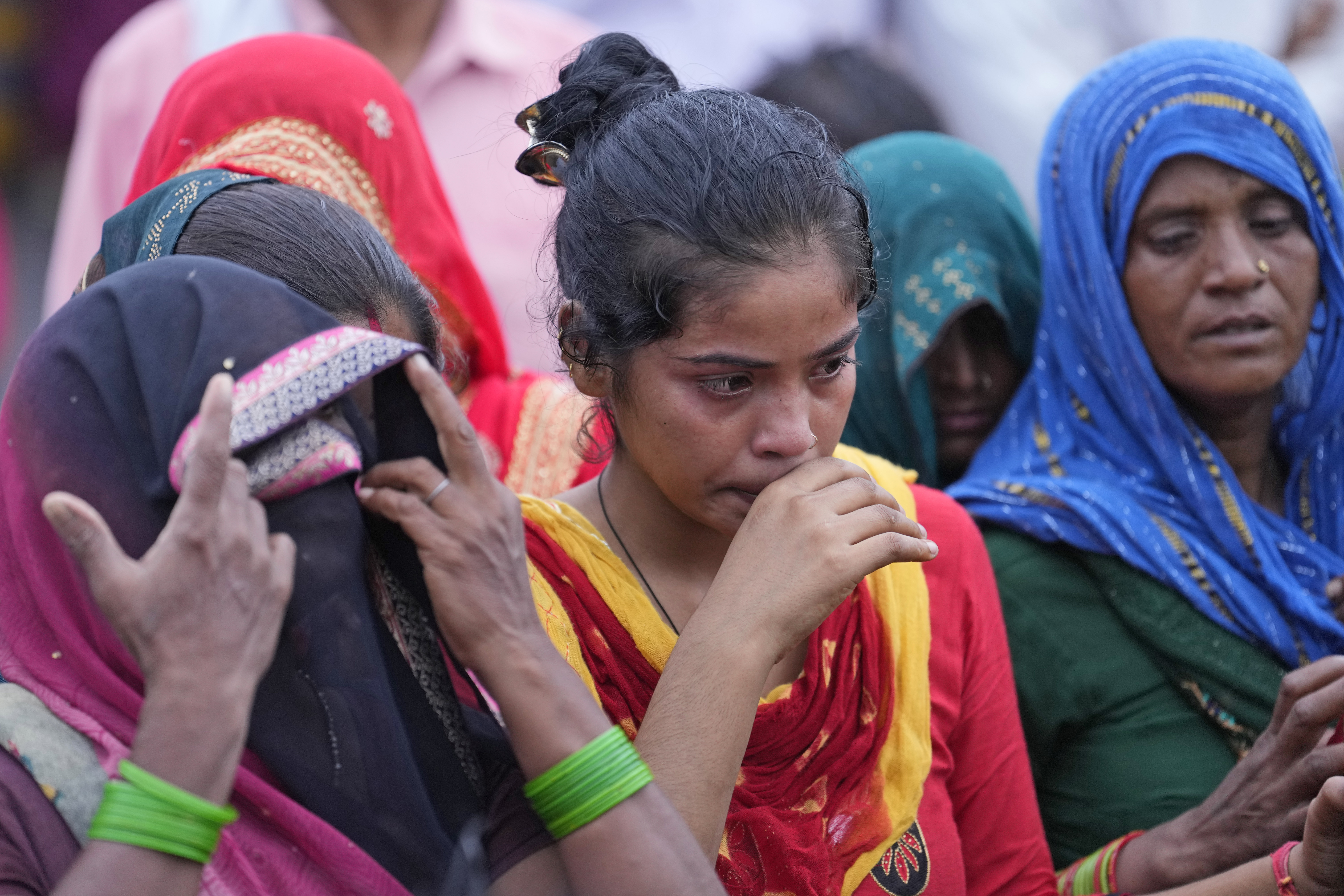 Villagers watch as family members prepare for the last rites of Savitri Devi