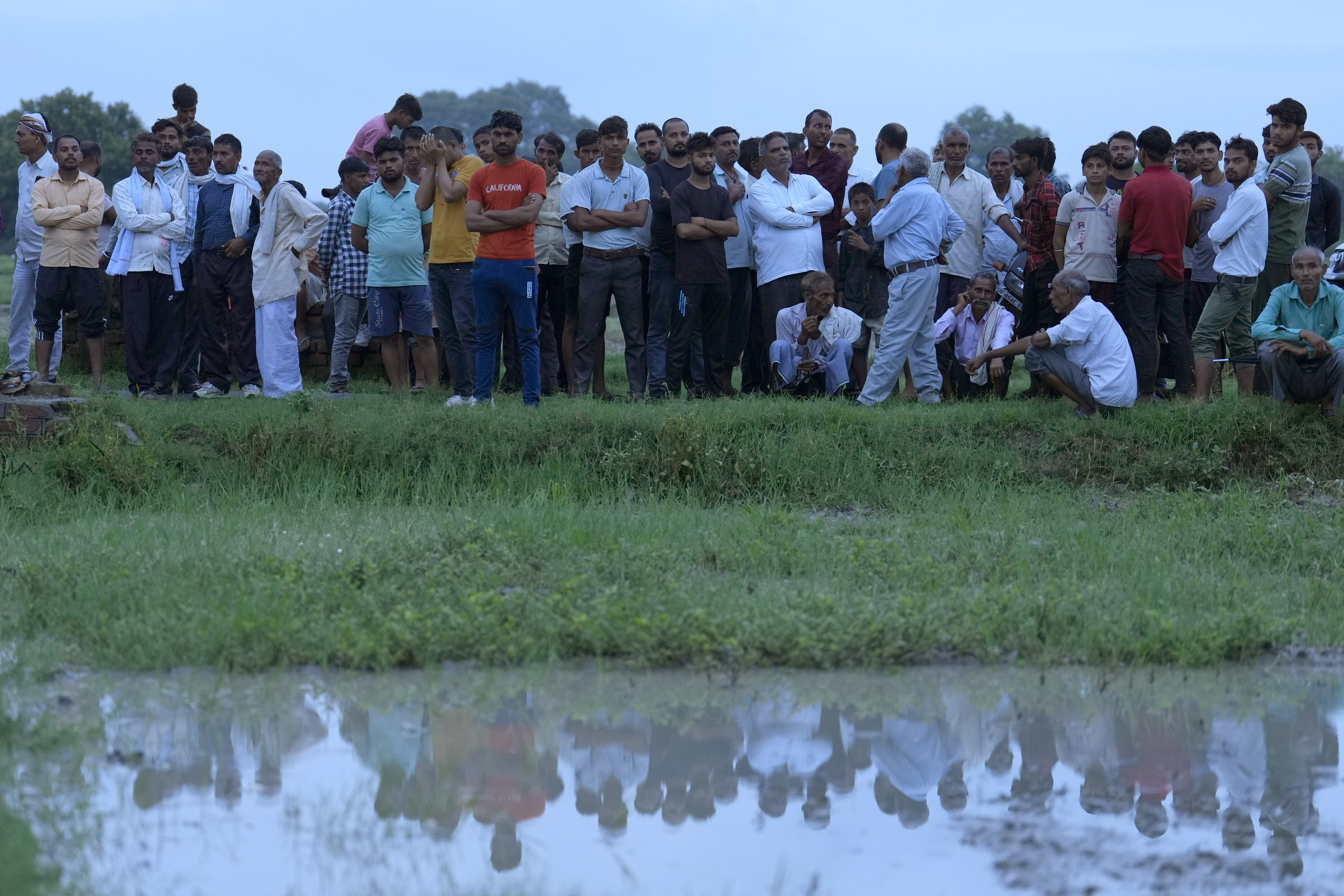 Villagers watch the cremation of Savitri Devi
