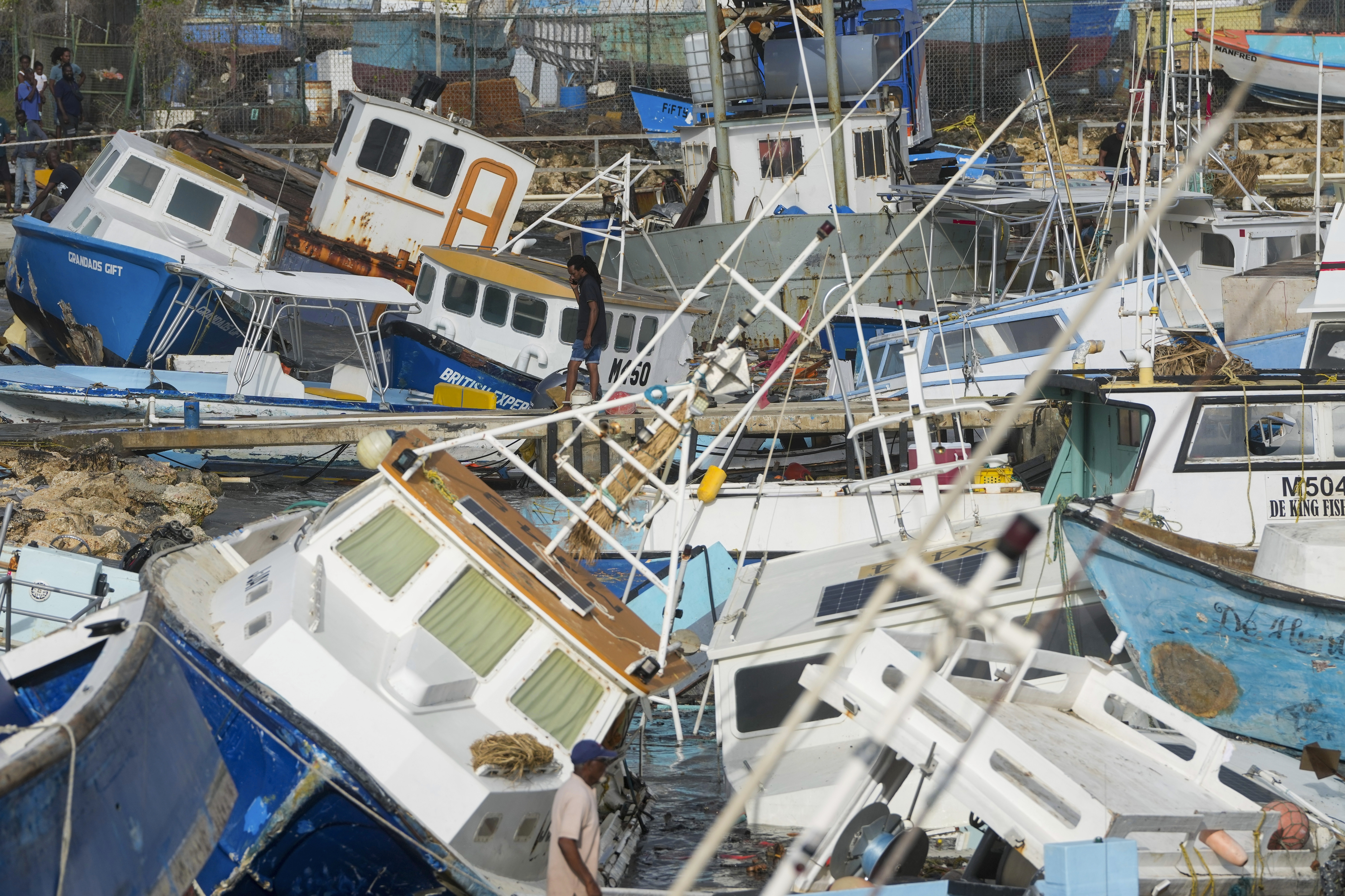 A fisherman looks at vessels damaged by Hurricane Beryl at the Bridgetown Fisheries in Barbados