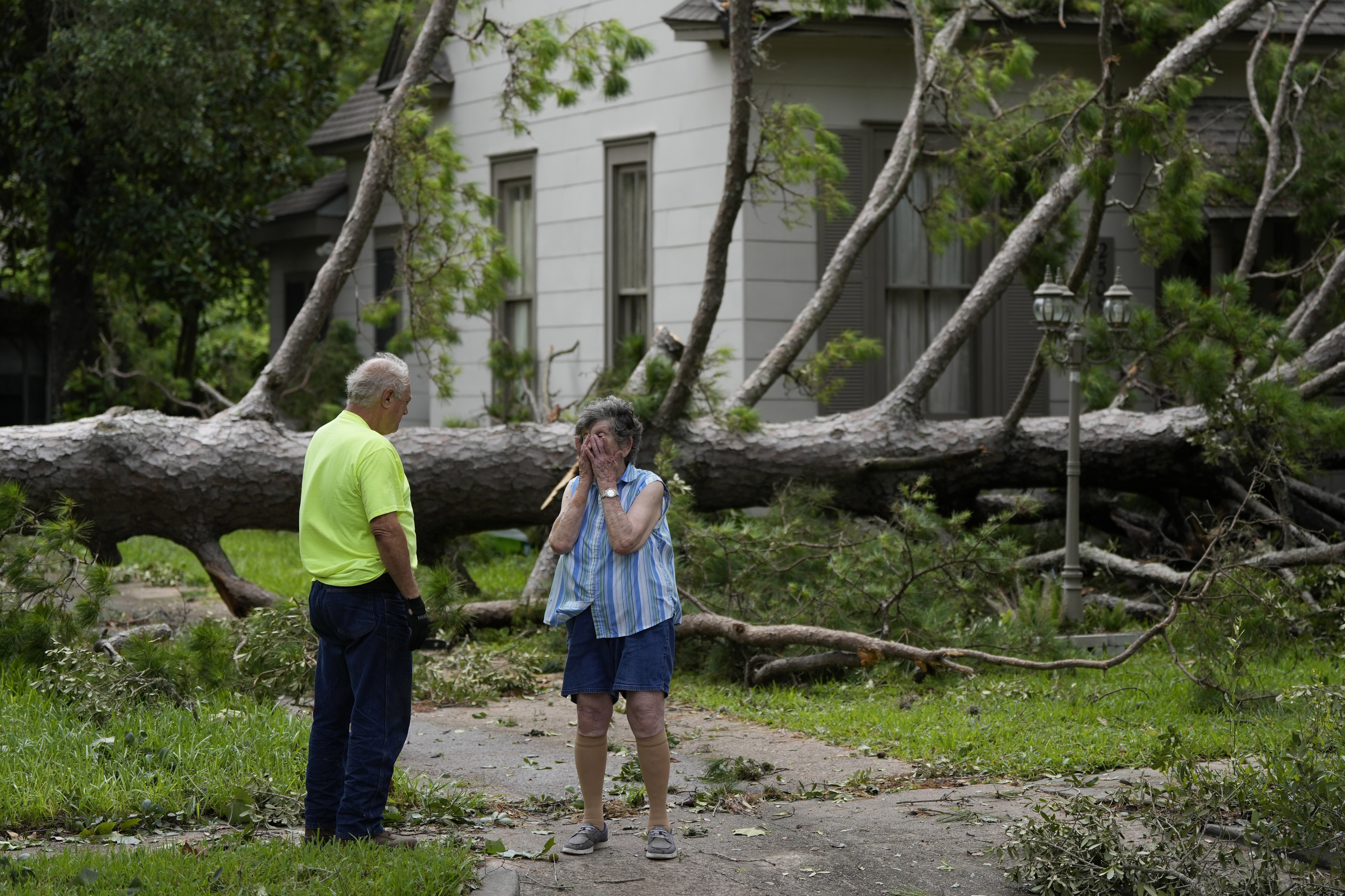 Jackie Jecmenek, right, talks with city worker Bobby Head as she stands in front of her neighbor's home