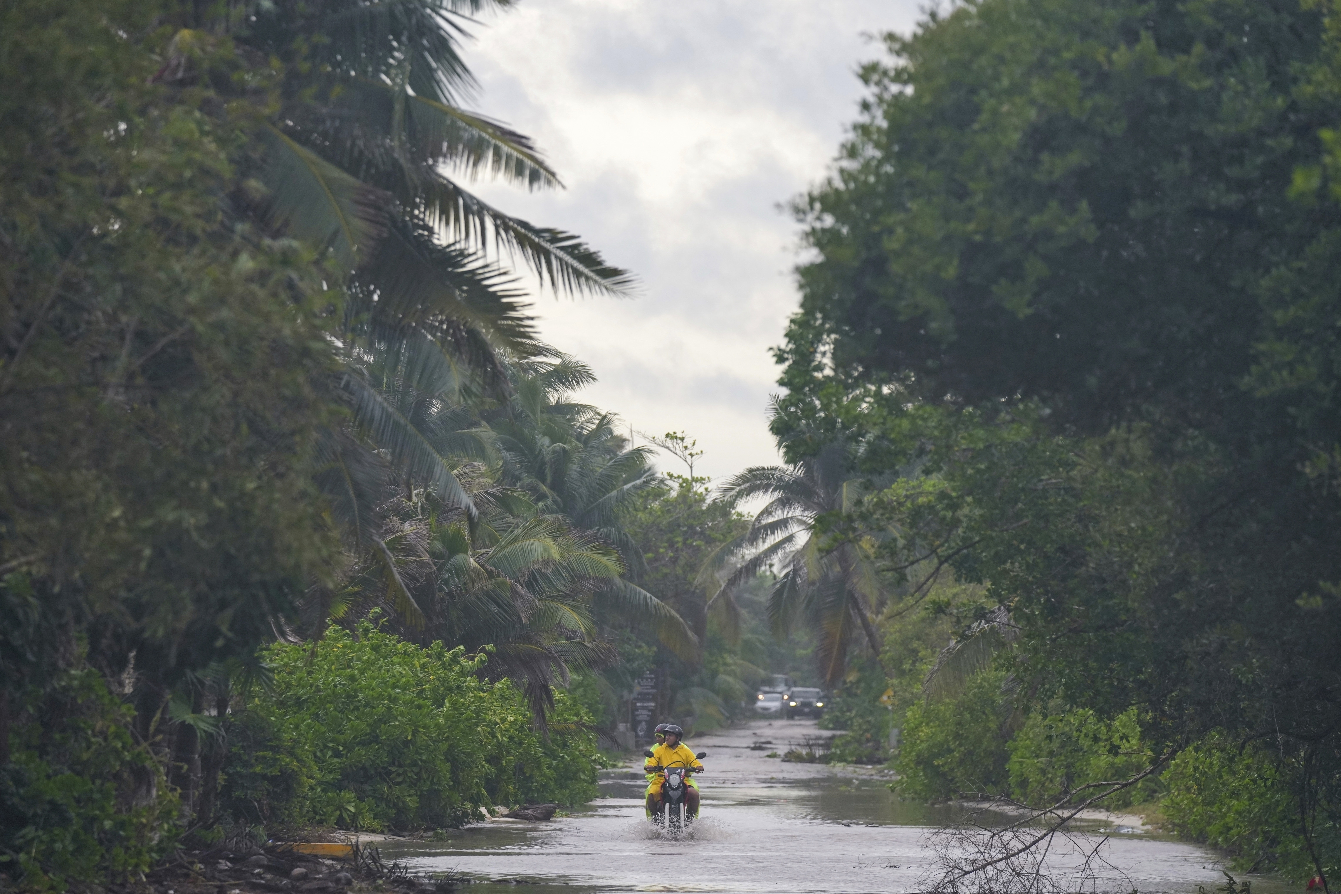 A motorcyclist manuevers a street flooded by heavy rains from Hurricane Beryl, in Tulum, Mexico