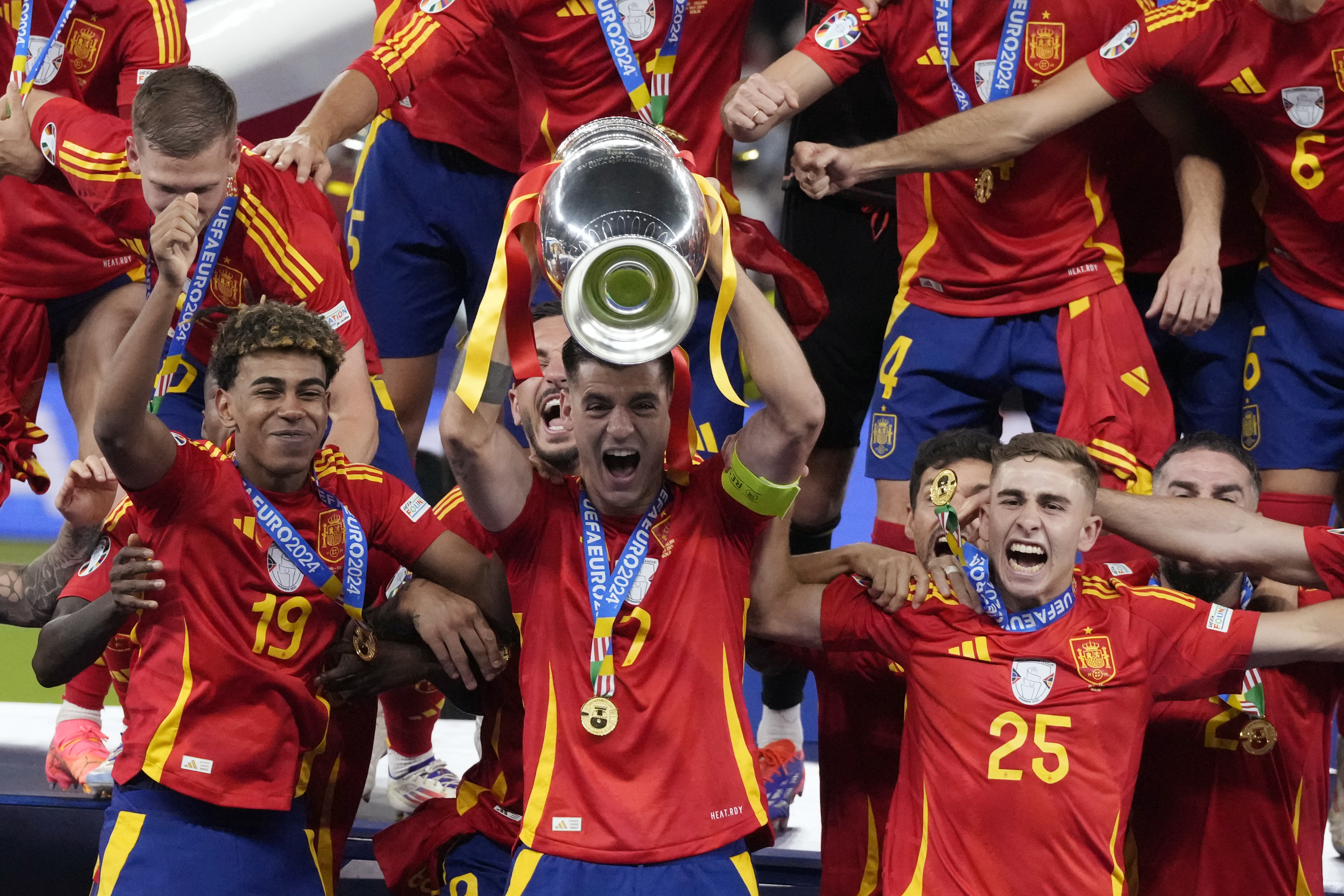 Spain's Alvaro Morata holds the trophy as he celebrates with his teammates