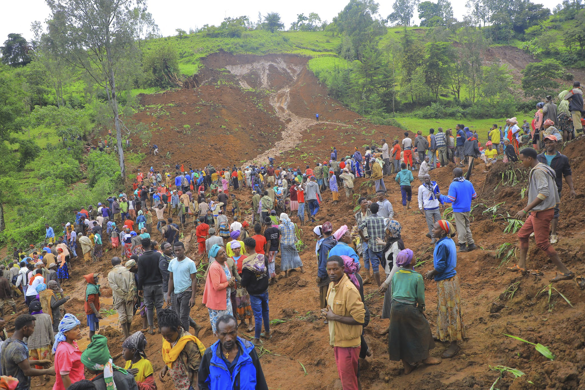 Hundreds of people gather at the site of two landslides in Ethiopia