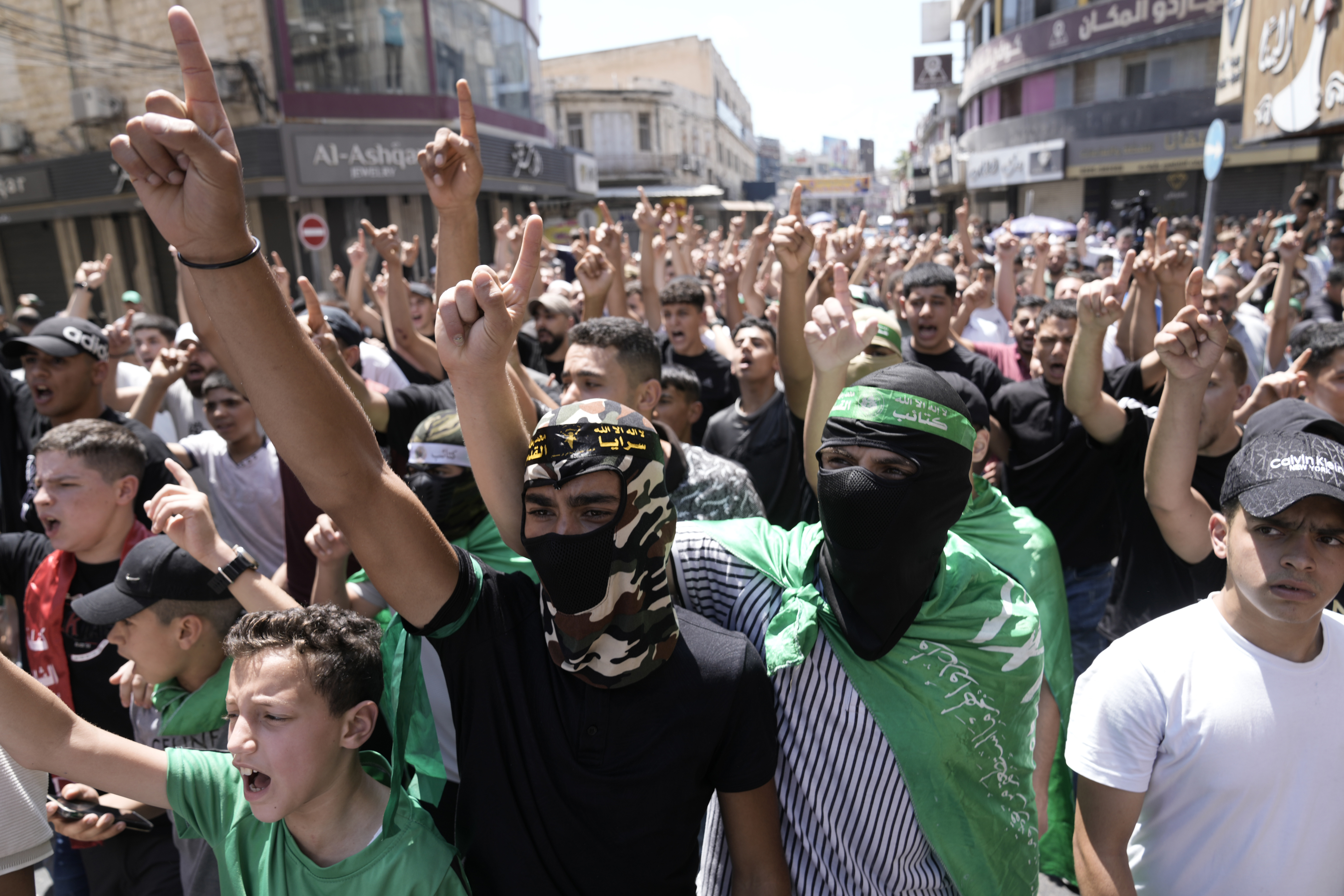 Palestinians wear Hamas militant group scarves and headbands as they protest the assassination of Hamas top leader Ismail Haniyeh, in the West Bank city of Nablus