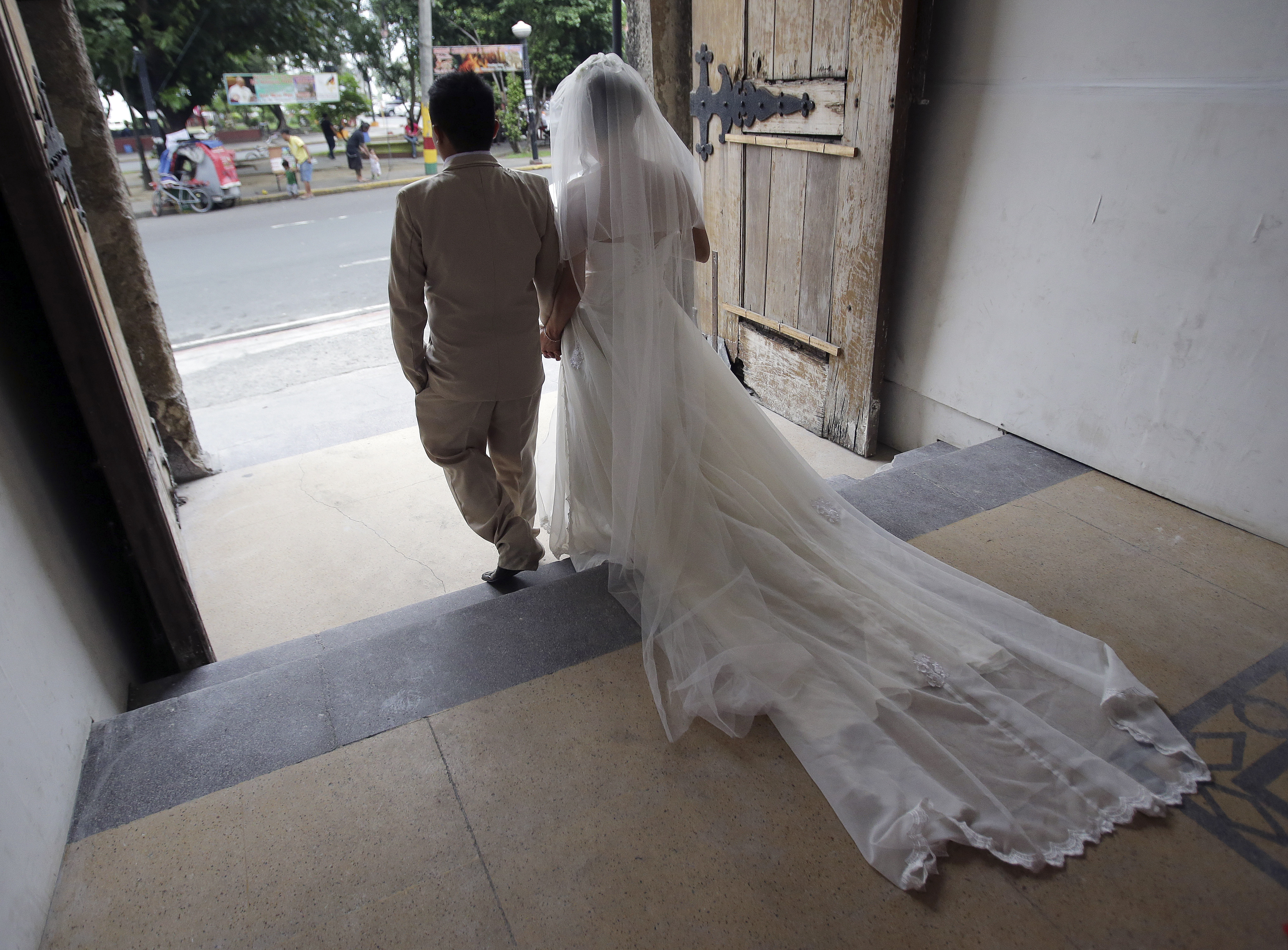 A newlywed Filipino couple walk out of a church