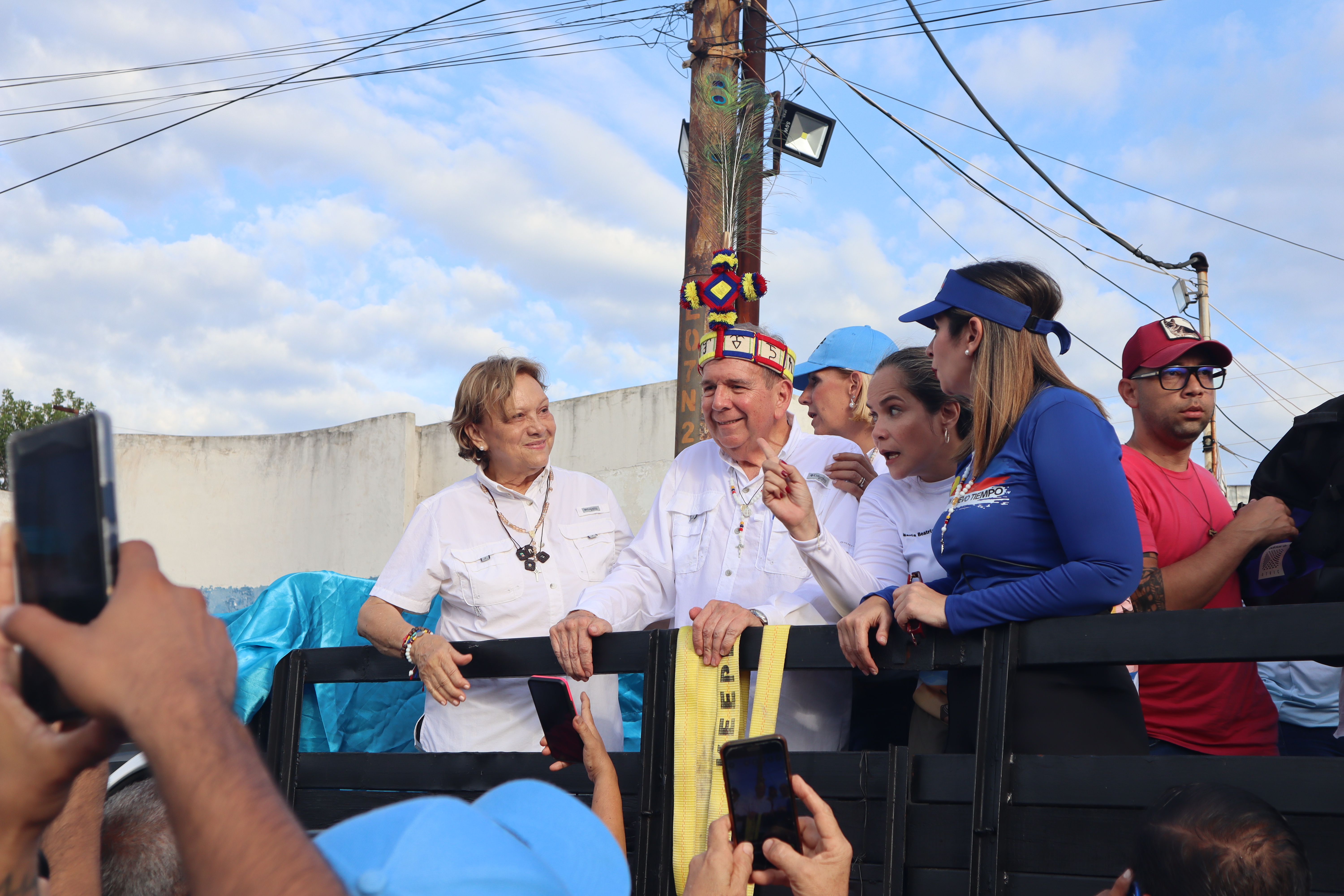 Edmundo González Urrutia, wearing a traditional headdress, parades through the streets on the back of a truck.