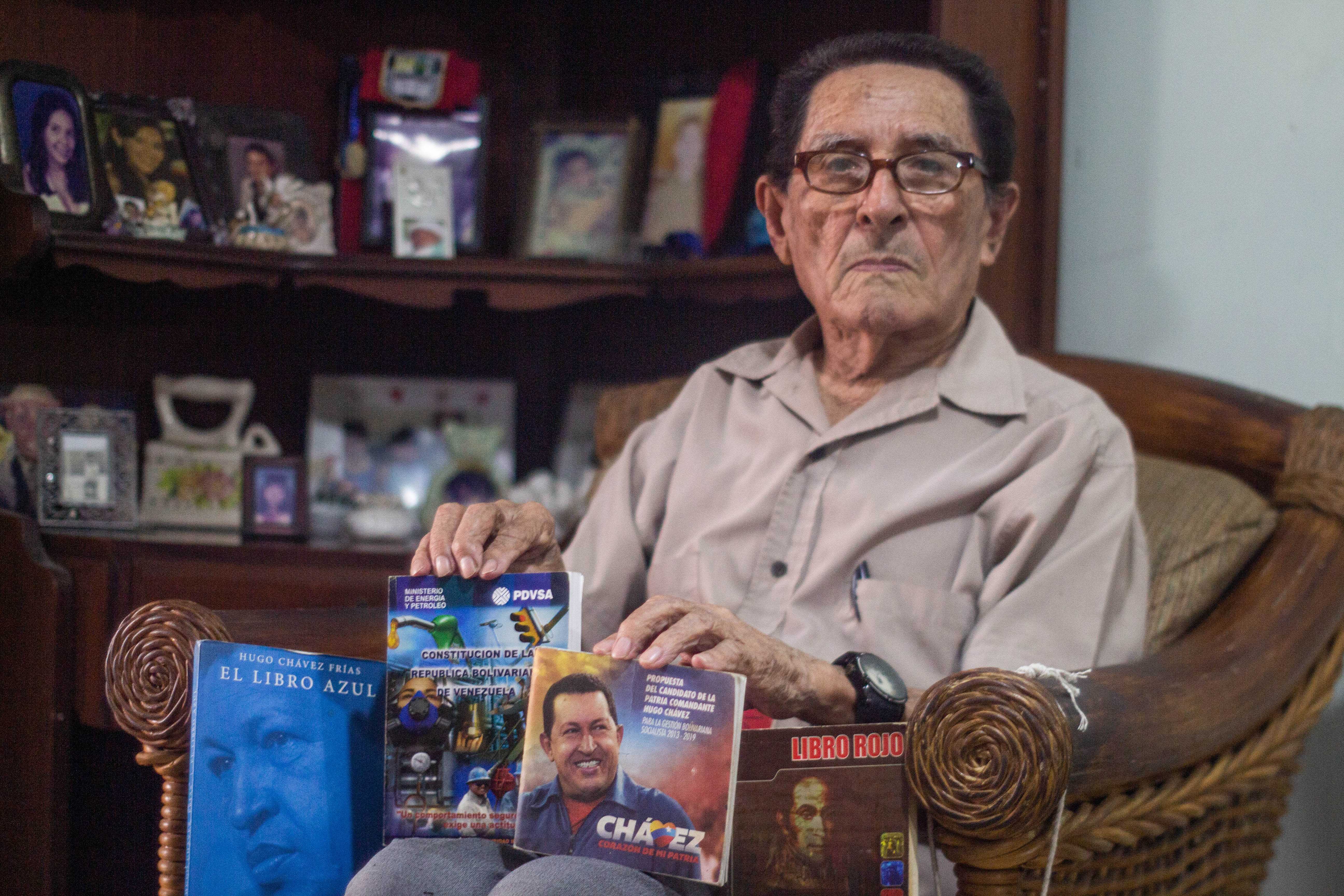 Luis Bermudez shows off his pro-Chavez and pro-Maduro booklets