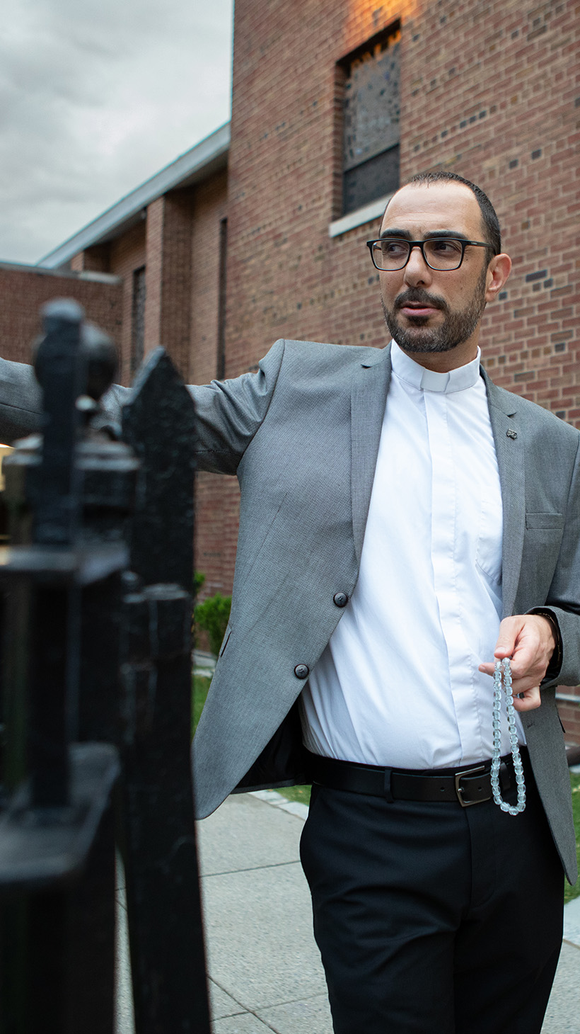 Dressed in a grey blazer and a high-collar preacher's shirt, Pastor Khalilia opens the wrought-iron gate to his red-brick church.