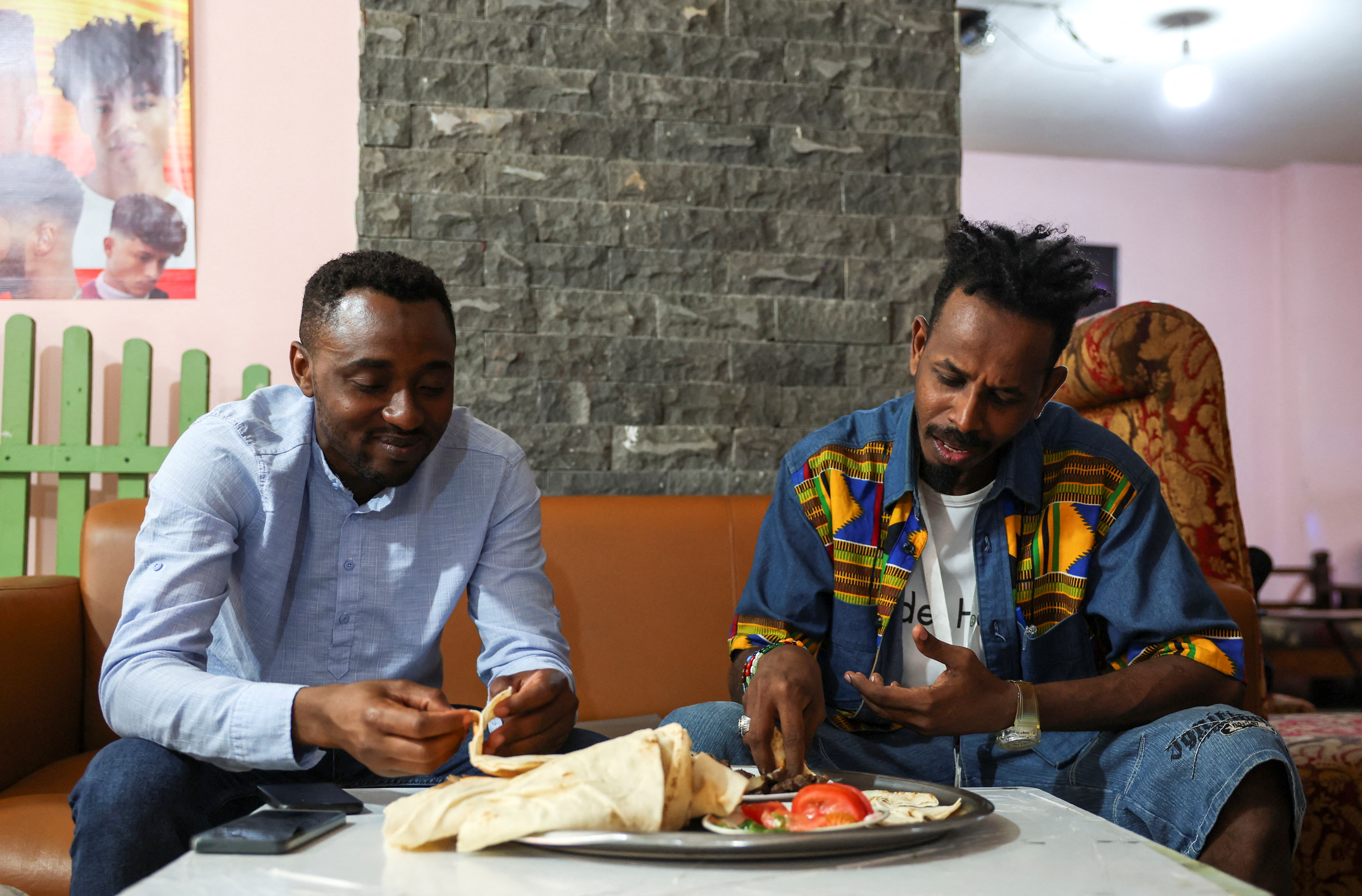 Sudanese Abdalbagi Osman Abdalbagi and his friend eat at a sudanese restaurant in Beirut, Lebanon June 26, 2023. REUTERS/ Emilie Madi