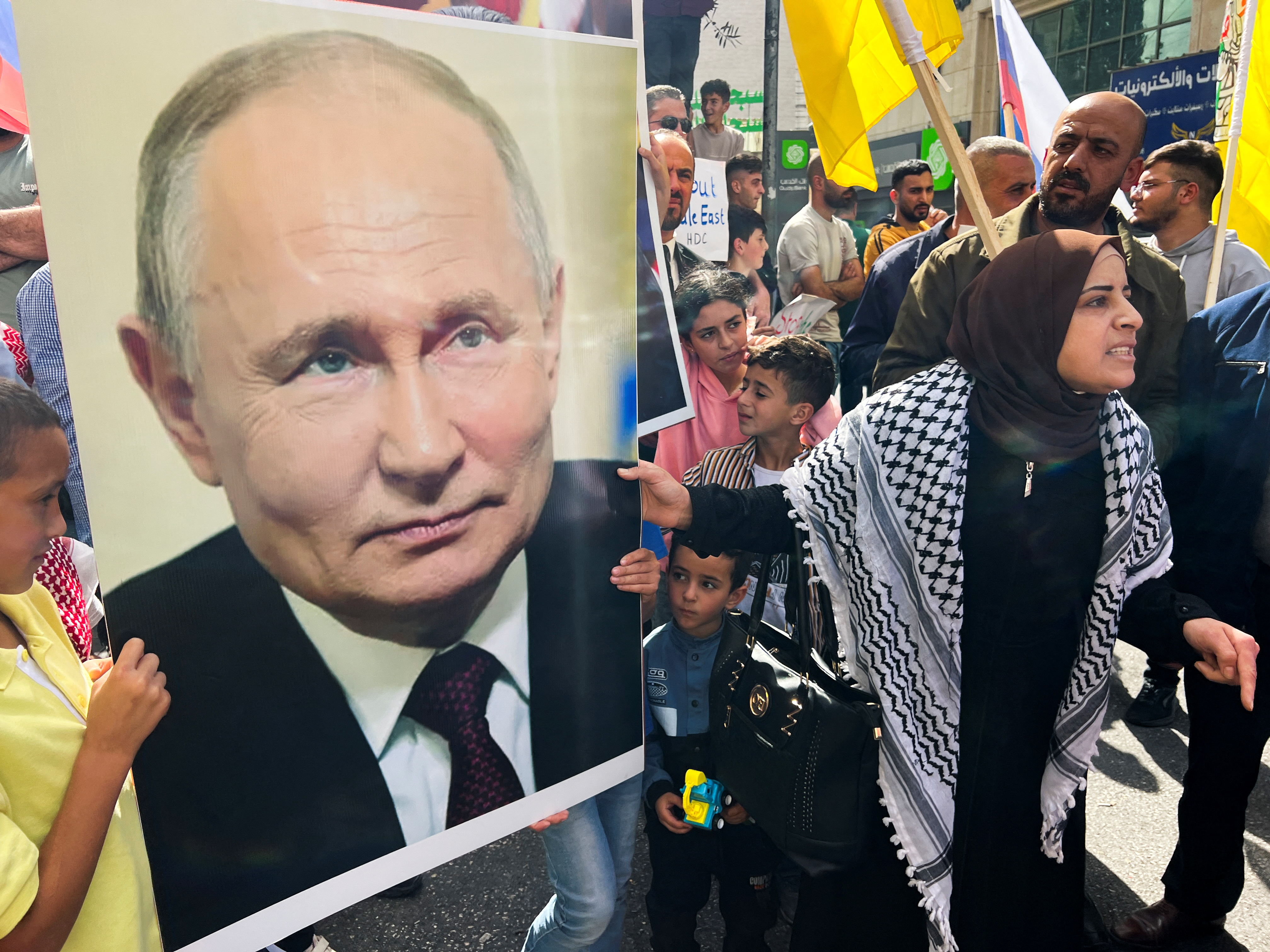 Palestinians hold a picture of the Russian President Vladimir Putin during a protest in support of the people of Gaza, as the conflict between Israel and Hamas continues, in Hebron in the Israeli-occupied West Bank, October 20, 2023. REUTERS/Yosri Aljamal