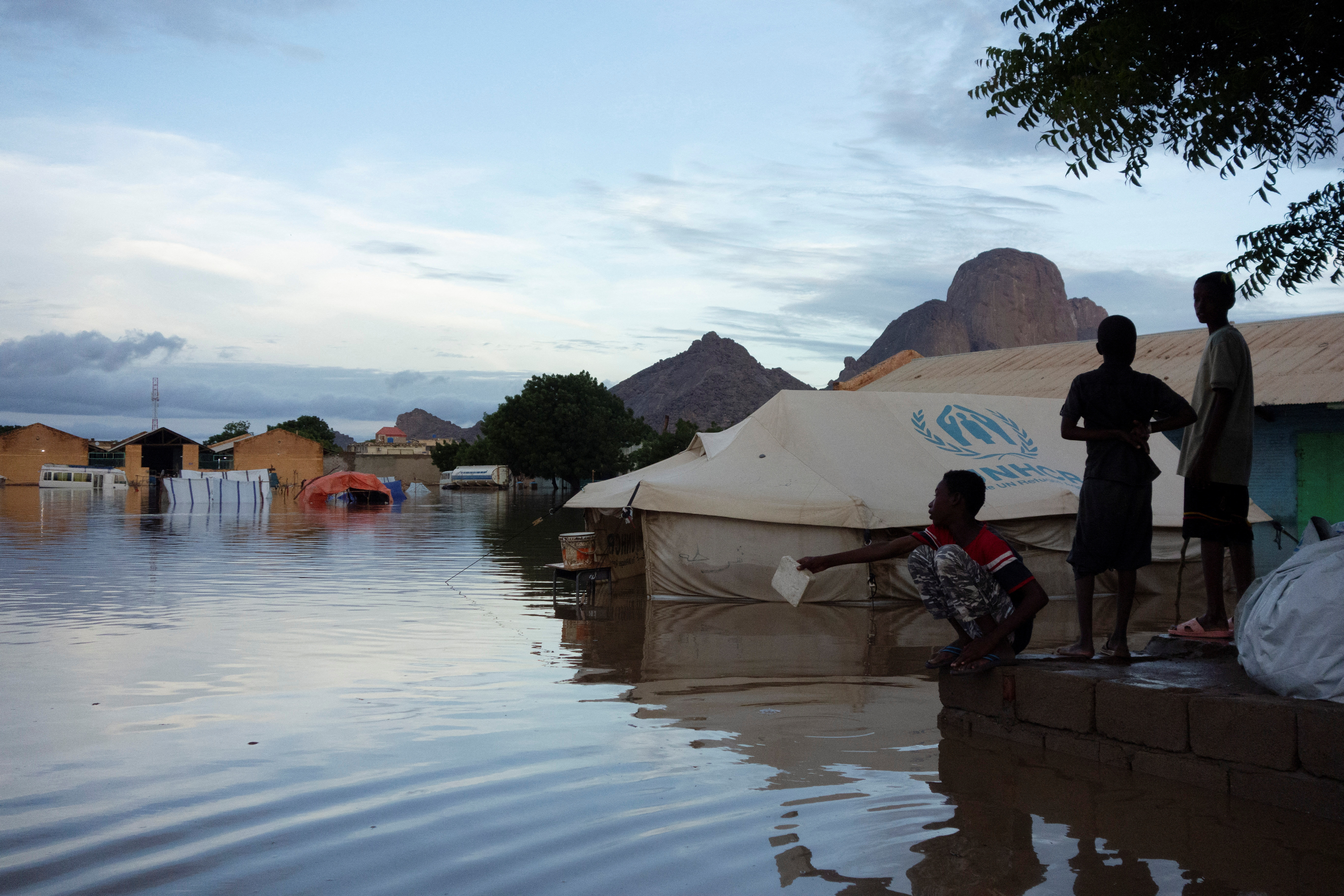 Displaced Sudanese children stand near a flooded UNHCR tent in Kassala, Sudan