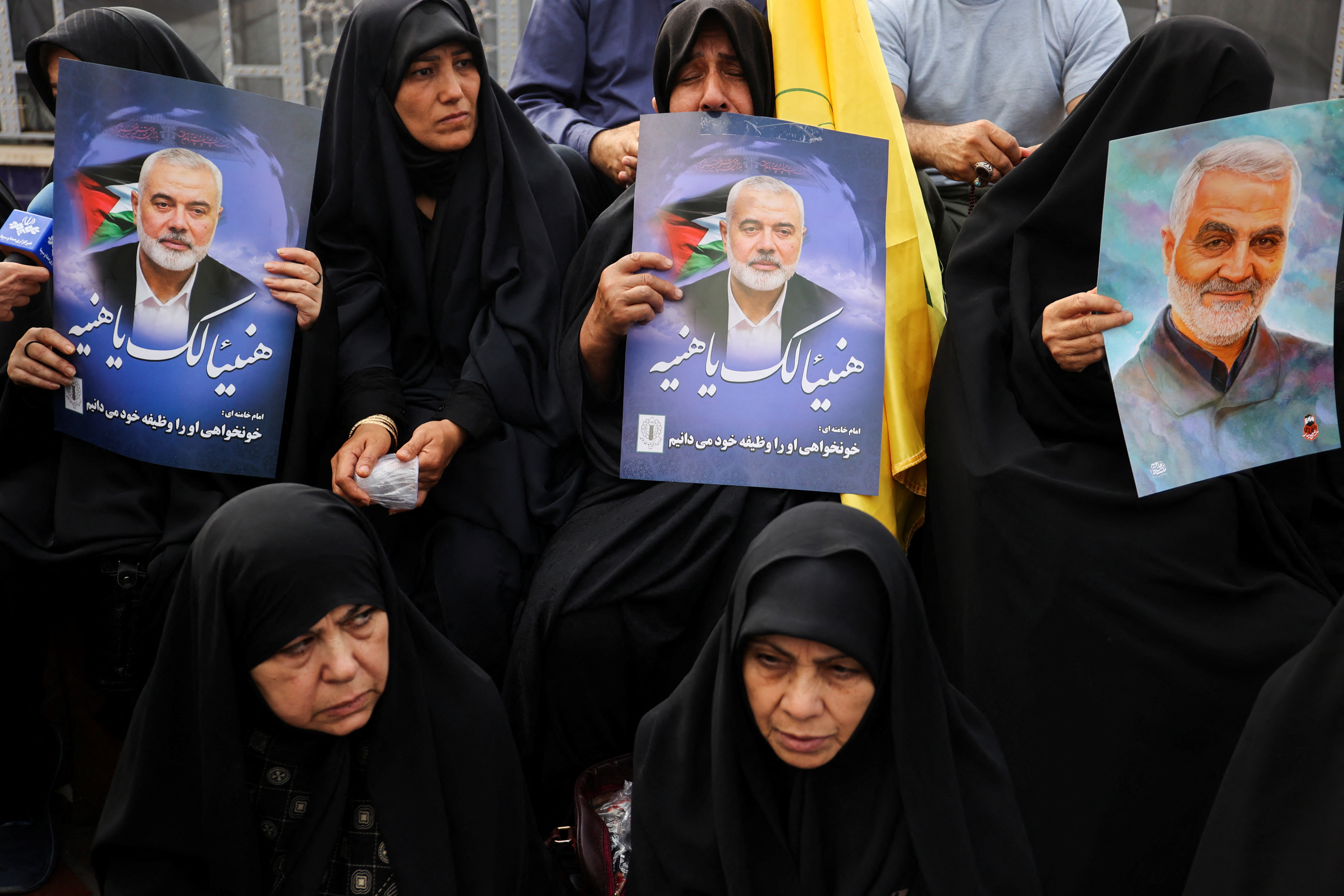 Iranians hold the poster of assassinated Hamas chief, Ismail Haniyeh during his funeral procession, in Tehran, Iran, August 1, 2024. Majid Asgaripour/WANA (West Asia News Agency) via REUTERS ATTENTION EDITORS - THIS IMAGE HAS BEEN SUPPLIED BY A THIRD PARTY.