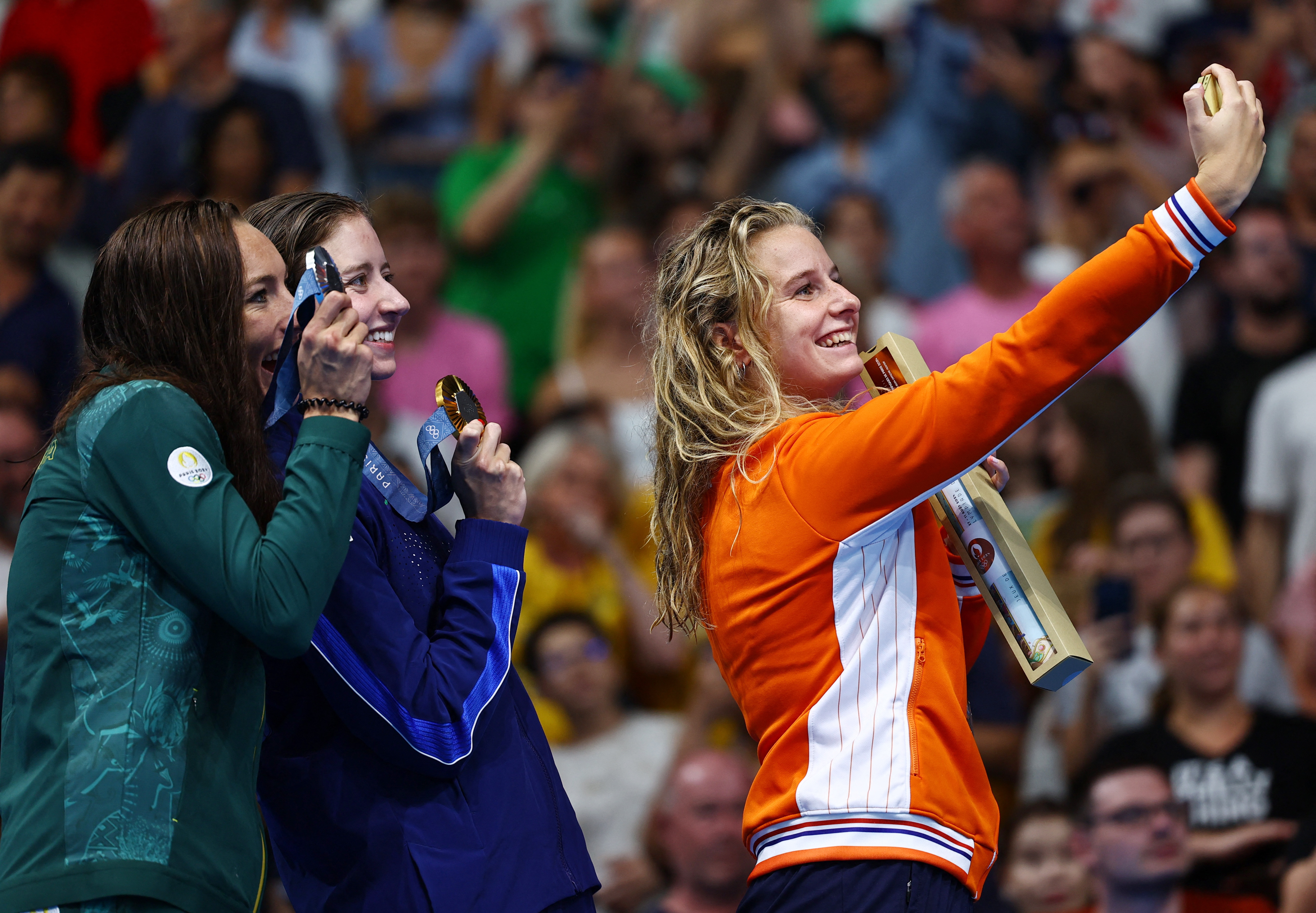 Paris 2024 Olympics - Swimming - Women's 200m Breaststroke Victory Ceremony - Paris La Defense Arena, Nanterre, France - August 01, 2024. Gold medallist Kate Douglass of United States poses for a selfie on the podium after winning with silver medallist Tatjana Smith of South Africa and bronze medallist Tes Schouten of Netherlands. REUTERS/Ueslei Marcelino