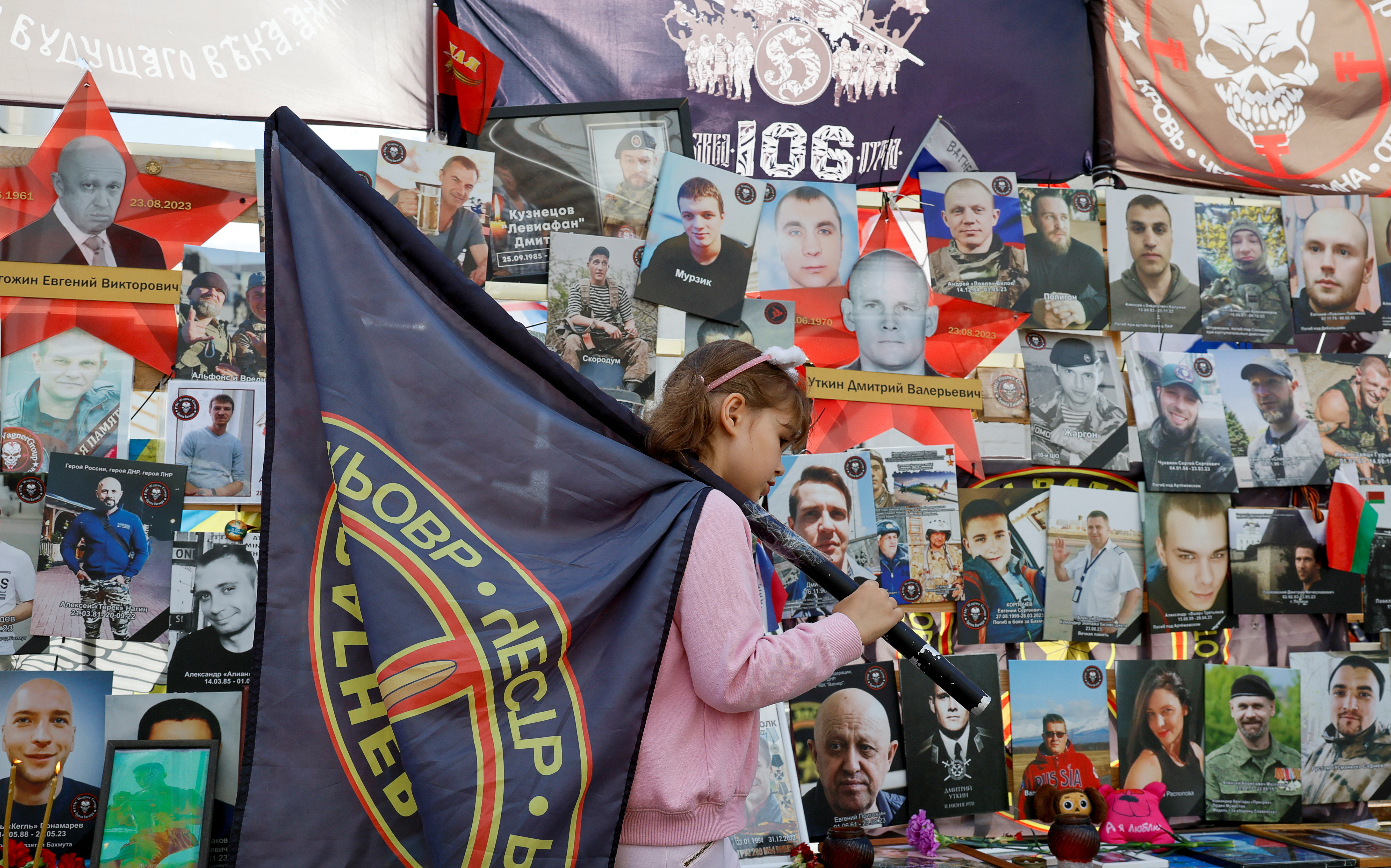 Ksenia, the daughter of a fallen soldier of Russia's Wagner mercenary group, stands in front of a makeshift memorial, which was erected following head of Wagner group Yevgeny Prigozhin and commander Dmitry Utkin's death in 2023, during a commemoration ceremony held to pay tribute to Wagner fighters, who were recently killed in Mali by northern Tuareg rebels,