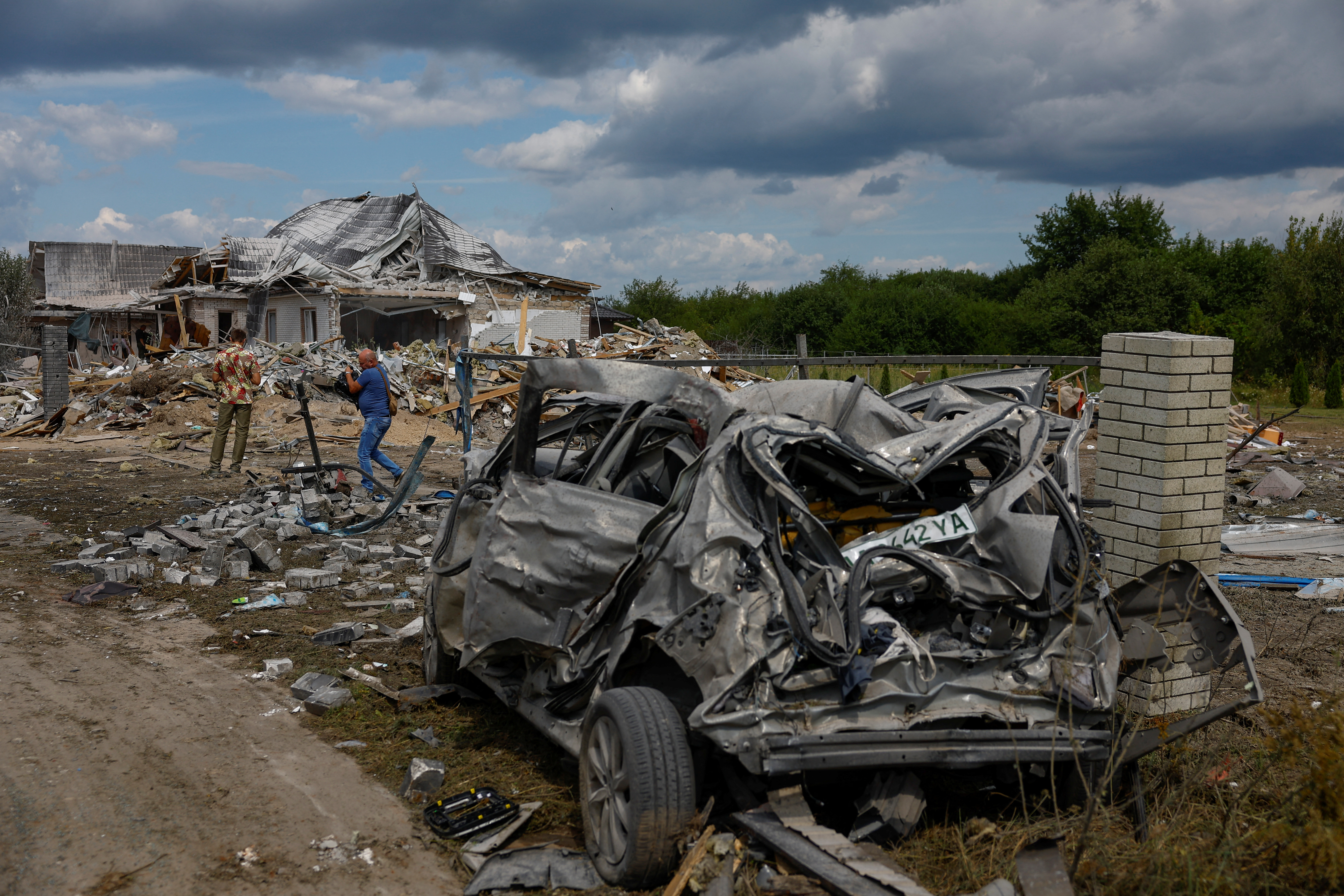 Men are seen at a site of a residential building heavily damaged during a Russian missile strike
