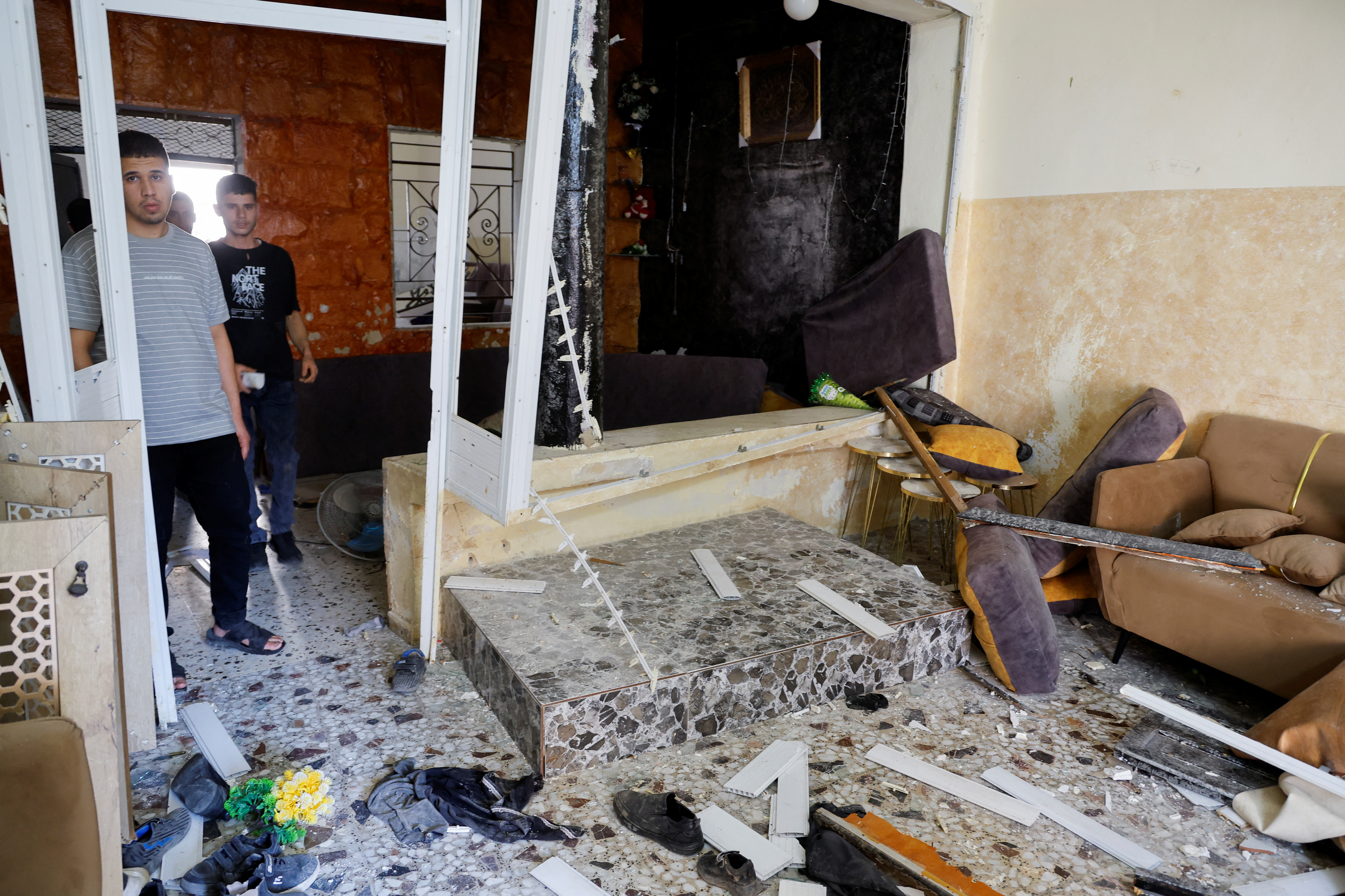 Palestinians inspect a house damaged in an Israeli raid, in Tubas