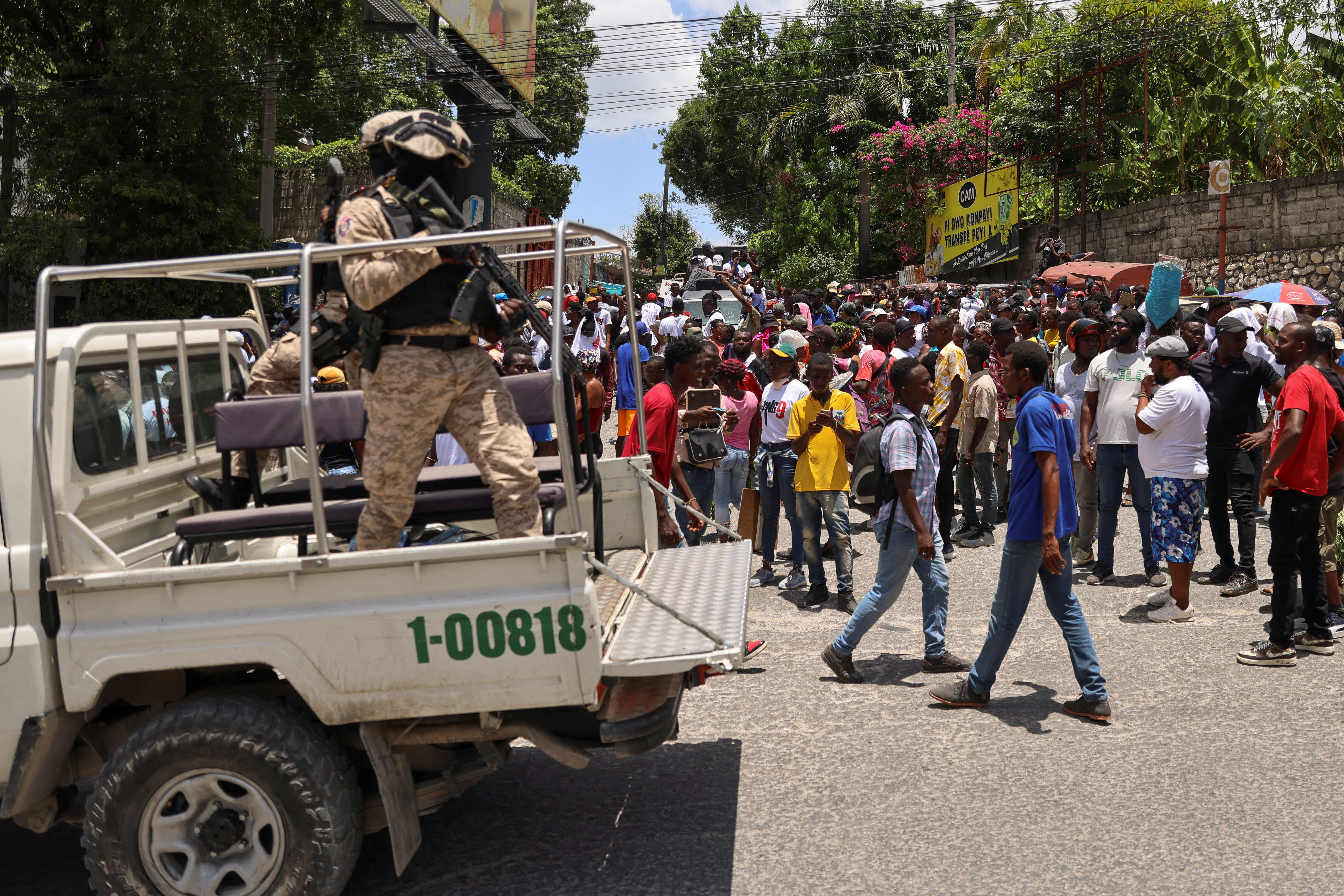 Police officers guard members of the coalition "Du Sang neuf" (New Blood) during a march against gang violence