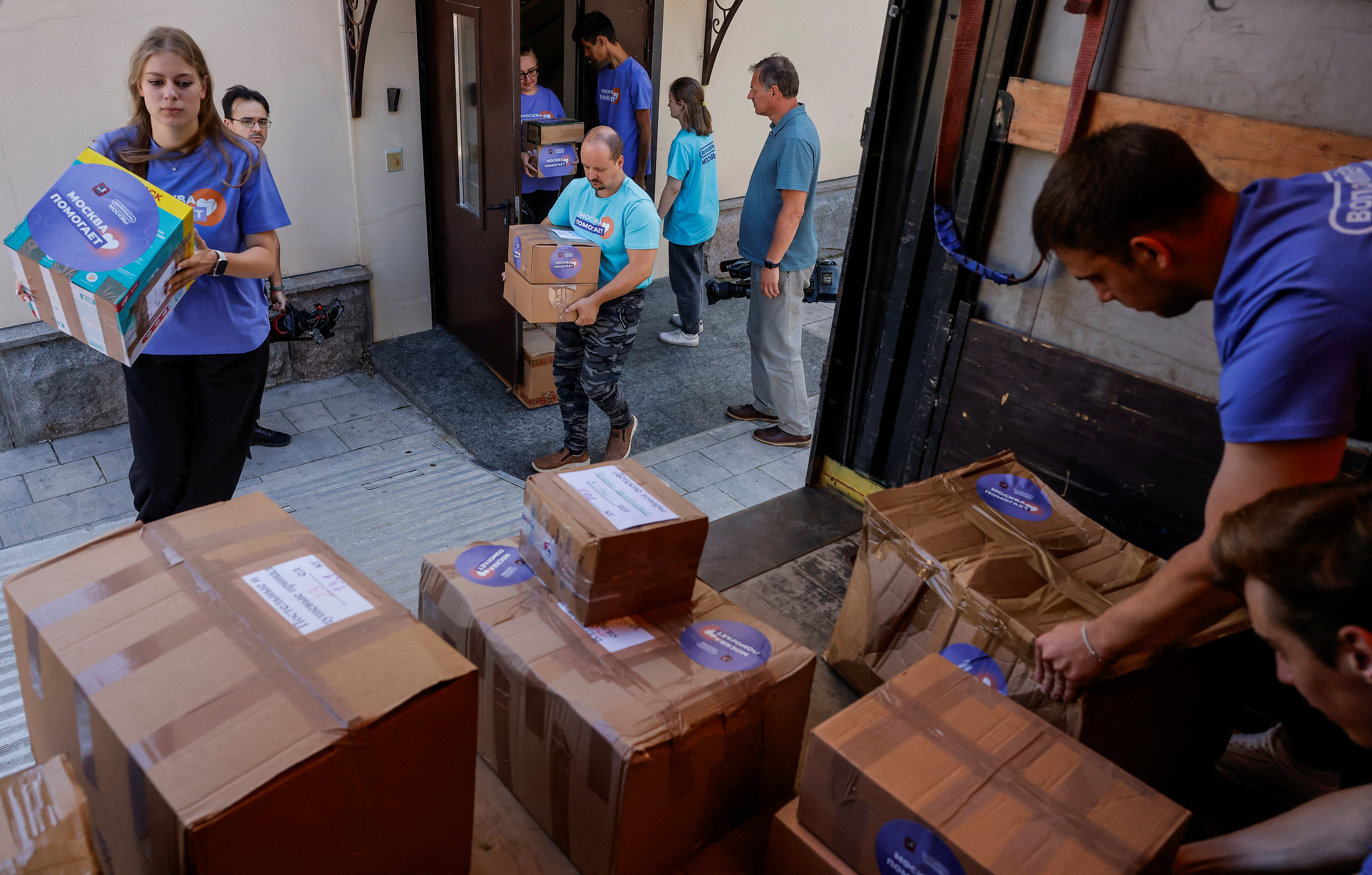 Volunteers load a truck with humanitarian aid intended for residents of the Kursk region, which was affected by an incursion of Ukrainian troops in the course of Russia-Ukraine conflict, in Moscow, Russia August 16, 2024. Signs on boxes and volunteers' T-shirts read: "Moscow helps". REUTERS/Maxim Shemetov
