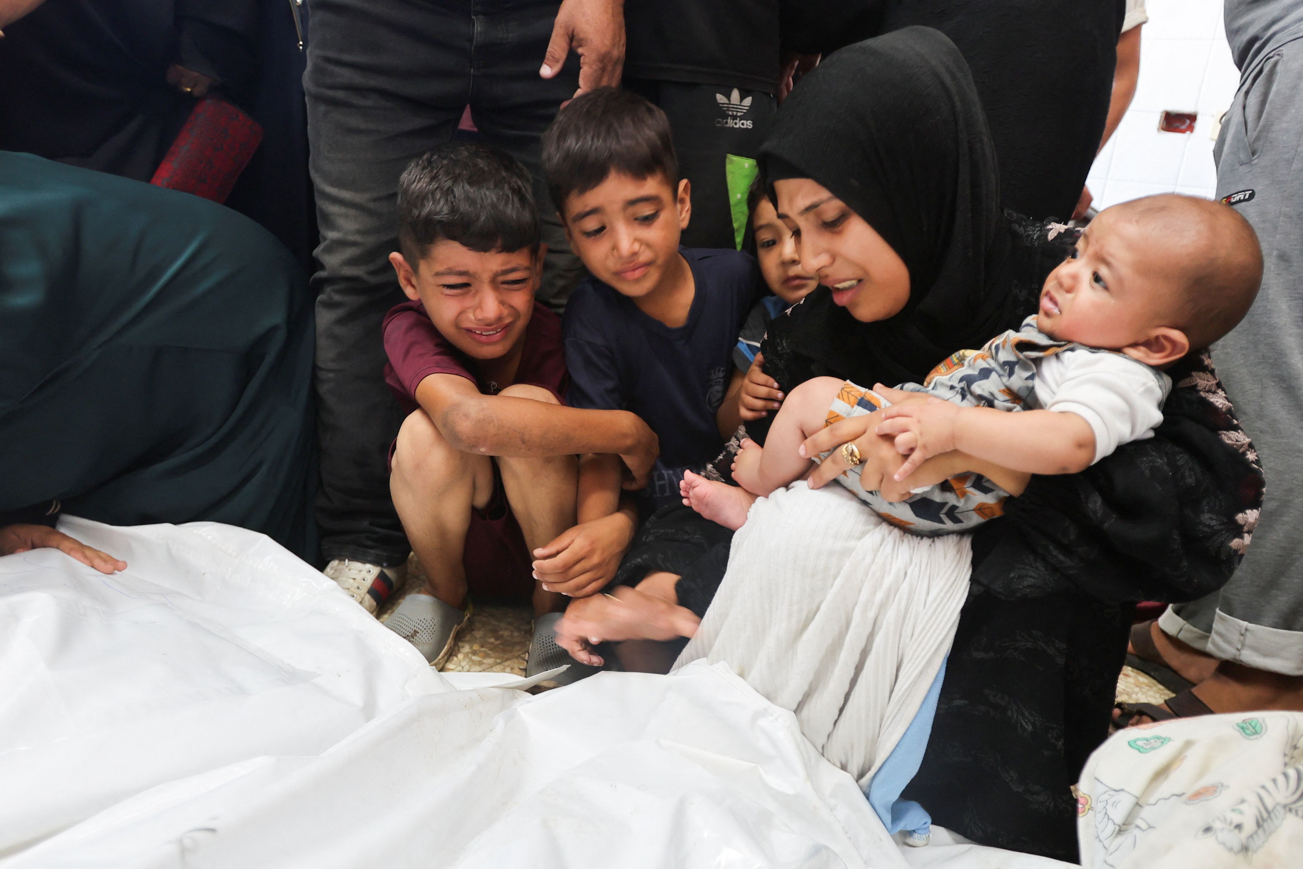Mourners react next to the bodies of Palestinians killed in Israeli strikes, amid the Israel-Hamas conflict, at Al-Aqsa Martyrs Hospital in Deir Al-Balah in the central Gaza Strip, August 18, 2024. REUTERS/Ramadan Abed