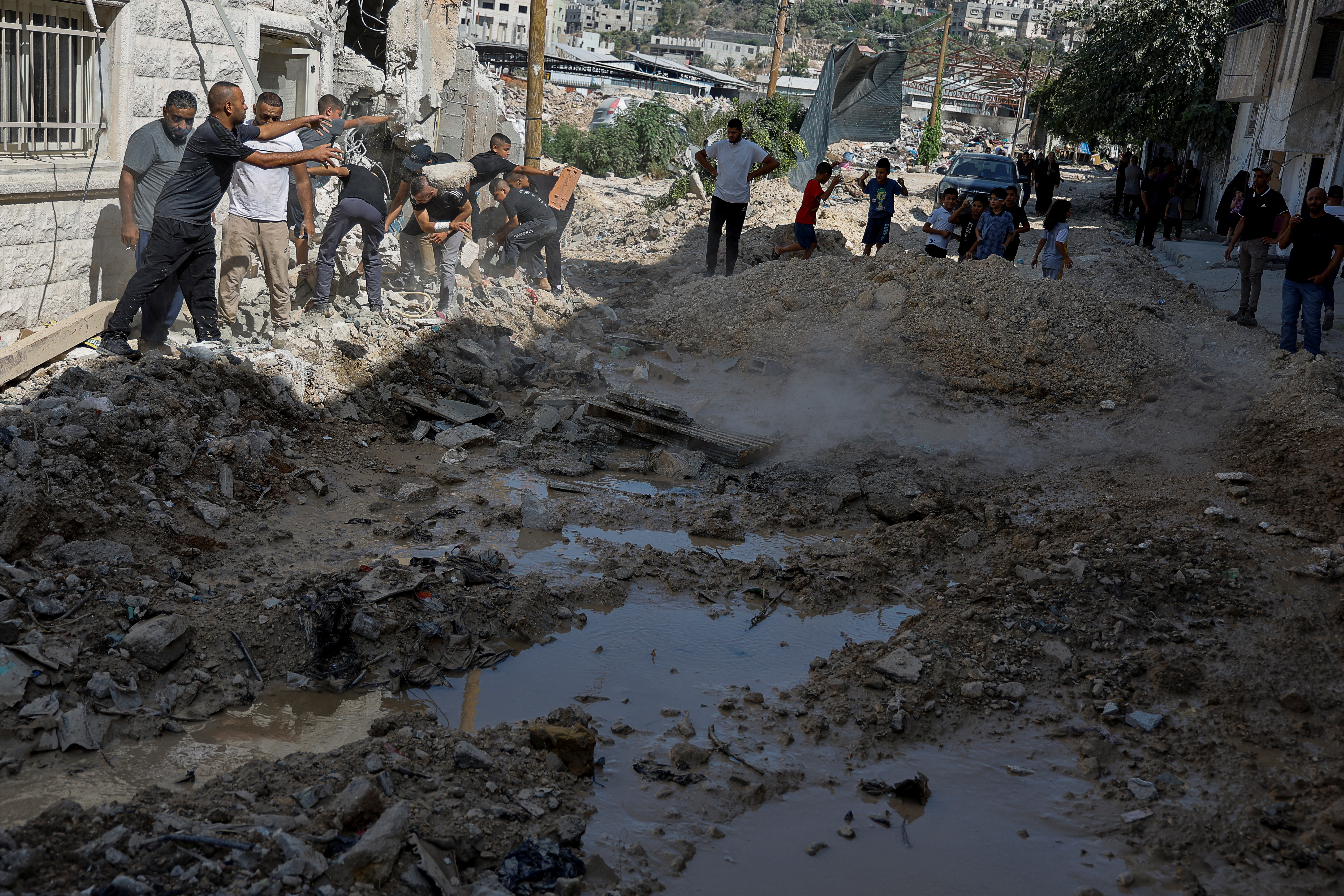 Palestinians clear rubble, as they inspect the damage, following an Israeli military raid, in Tulkarm, in the Israeli-occupied West Bank
