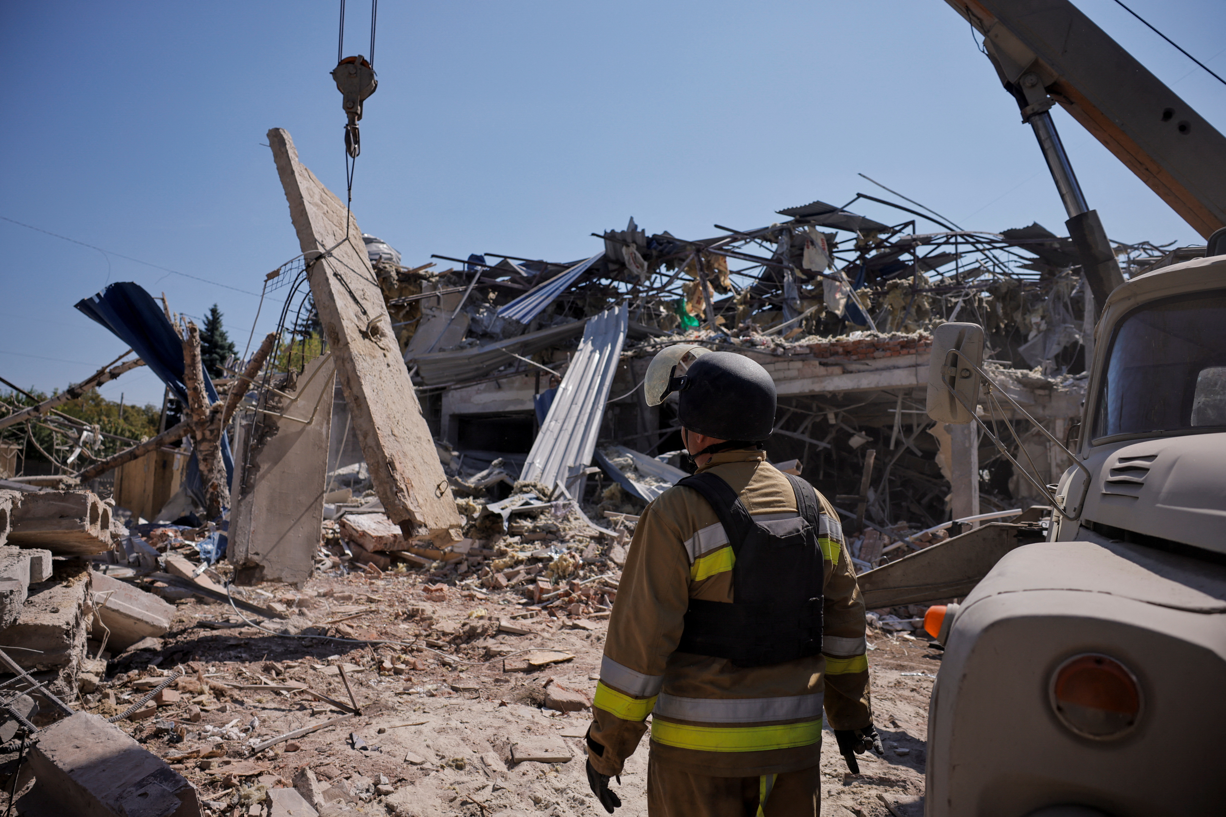 A Ukrainian emergency person works among the rubble of a destroyed hotel following a Russian strike