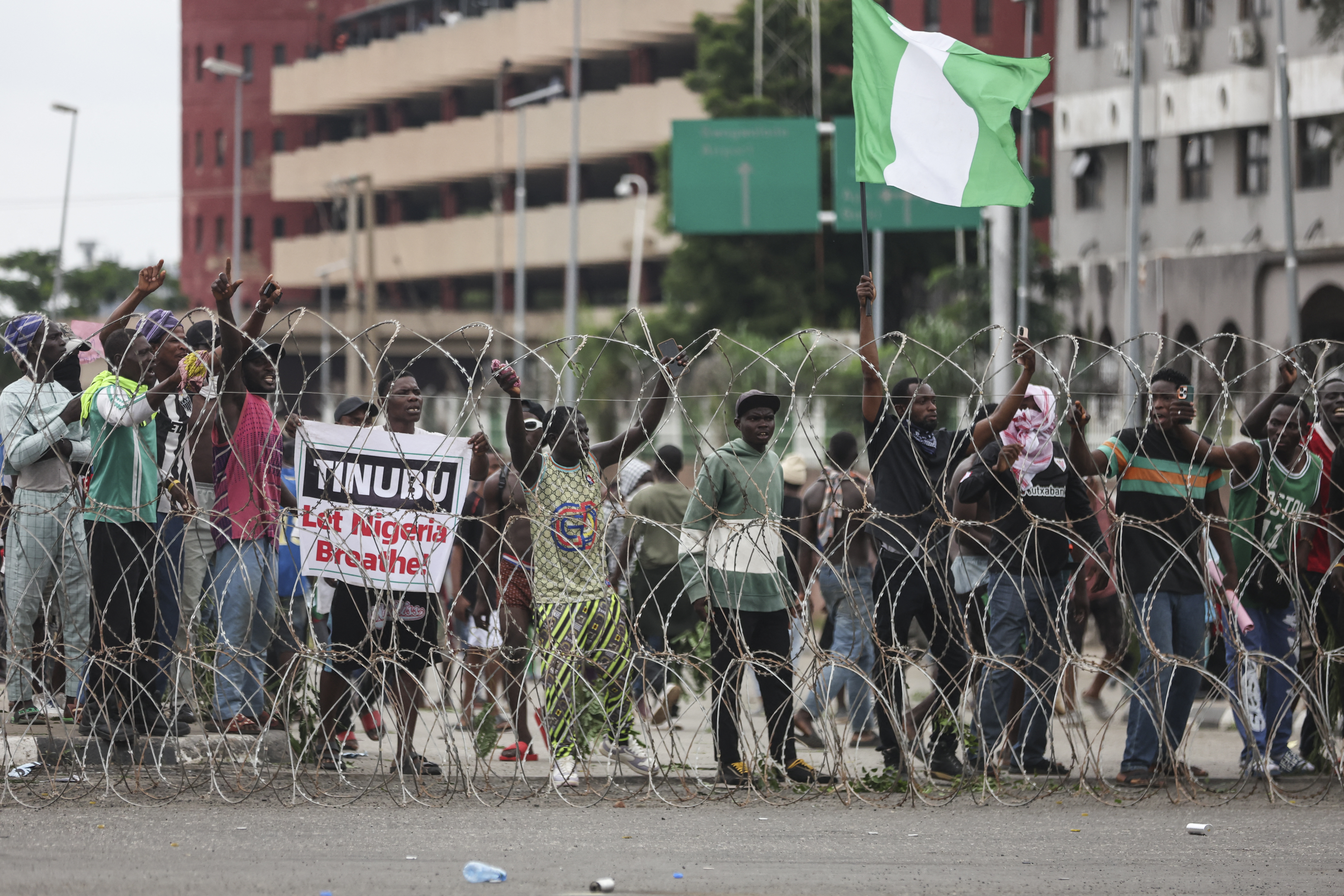 Protestors hold a placard as they gather behind barbed wire during the End Bad Governance protest in Abuja