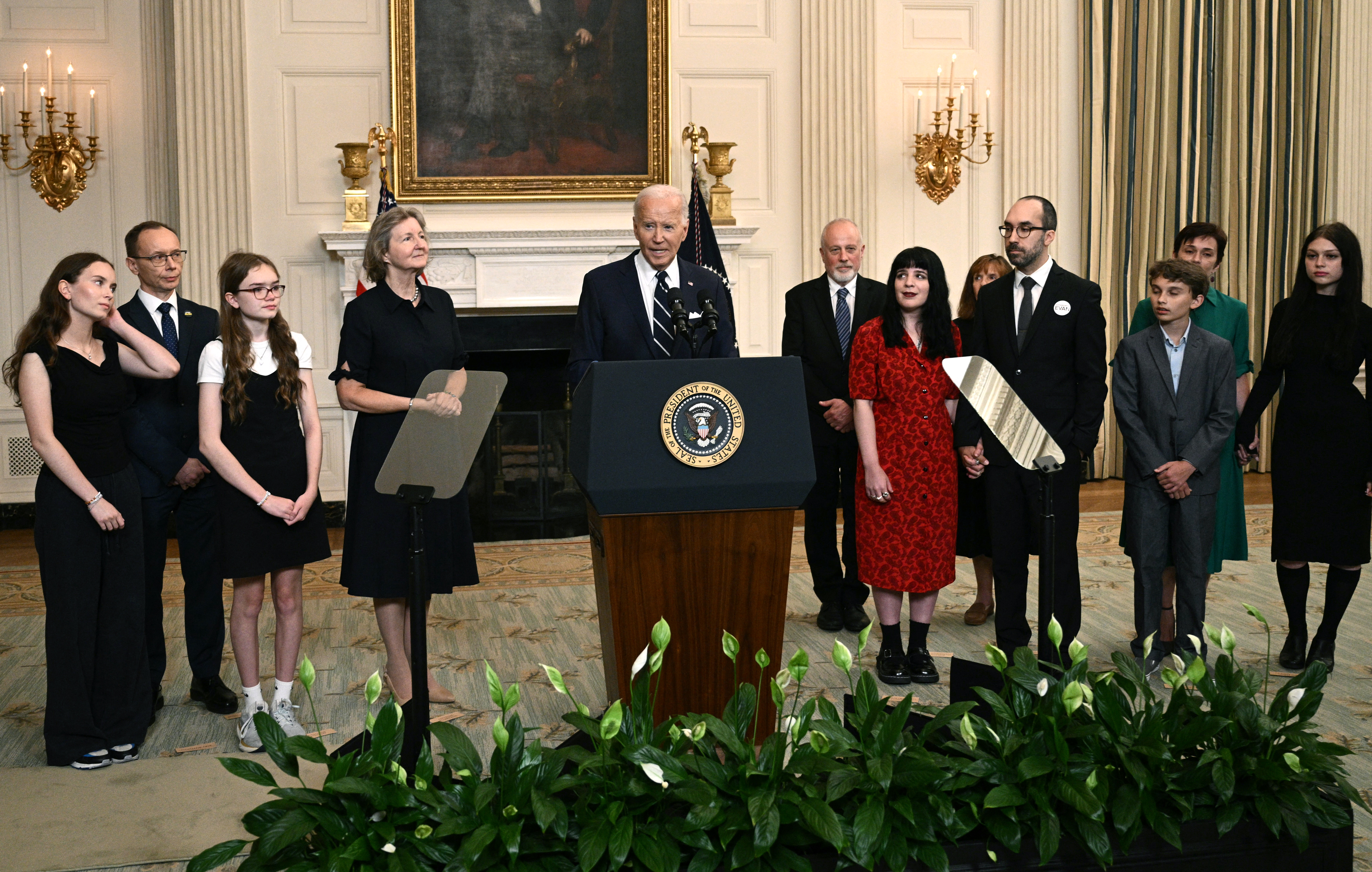 US President Joe Biden, standing alongside family members of the freed prisoners, speaks about the prisoner exchange with Russia, in the State Dining Room of the White House in Washington, DC, on August 1, 2024. - Biden hailed the prisoner swap with Russia that saw the return of US journalist Evan Gershkovich and former US Marine Paul Whelan on Thursday as a "feat of diplomacy" that has ended their "agony." (Photo by Brendan SMIALOWSKI / AFP)