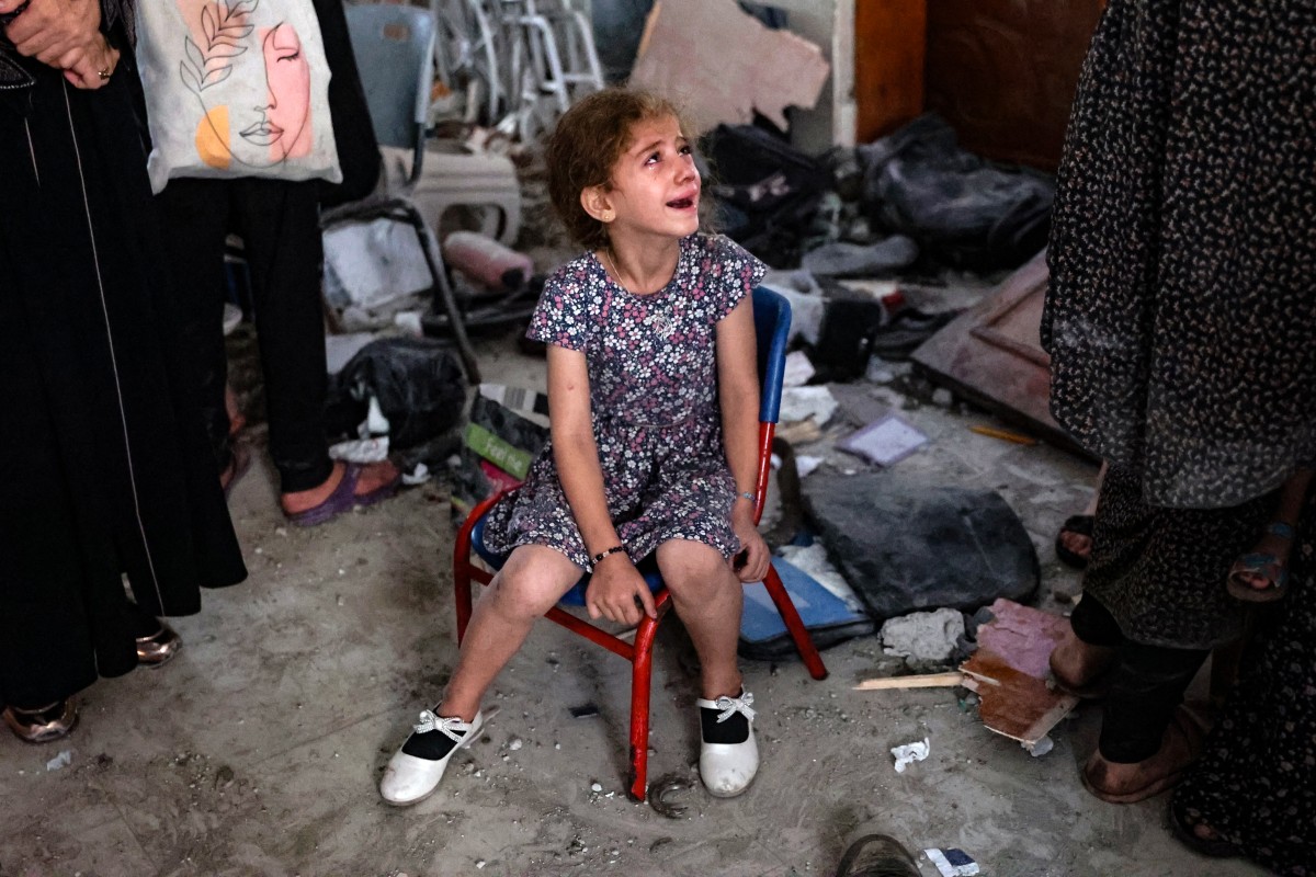 A young girl cries inside a school used as a temporary shelter for displaced Palestinians in Gaza City, following an Israeli strike on August 10, 2024, that killed more than 90 people. (Photo by Omar AL-QATTAA / AFP)