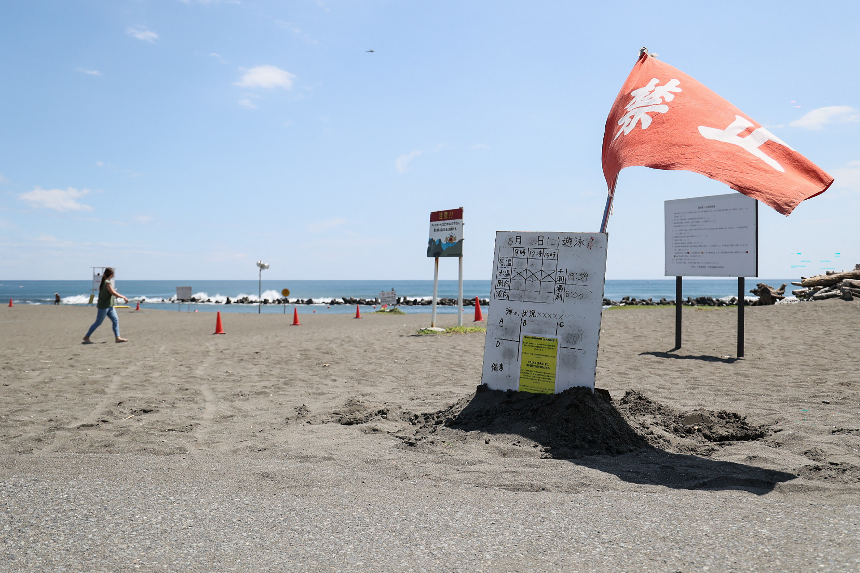 A red flag flutters in the wind as authorities warn against swimming at Shonan Bellmare Hiratsuka Beach Park in Hiratsuka