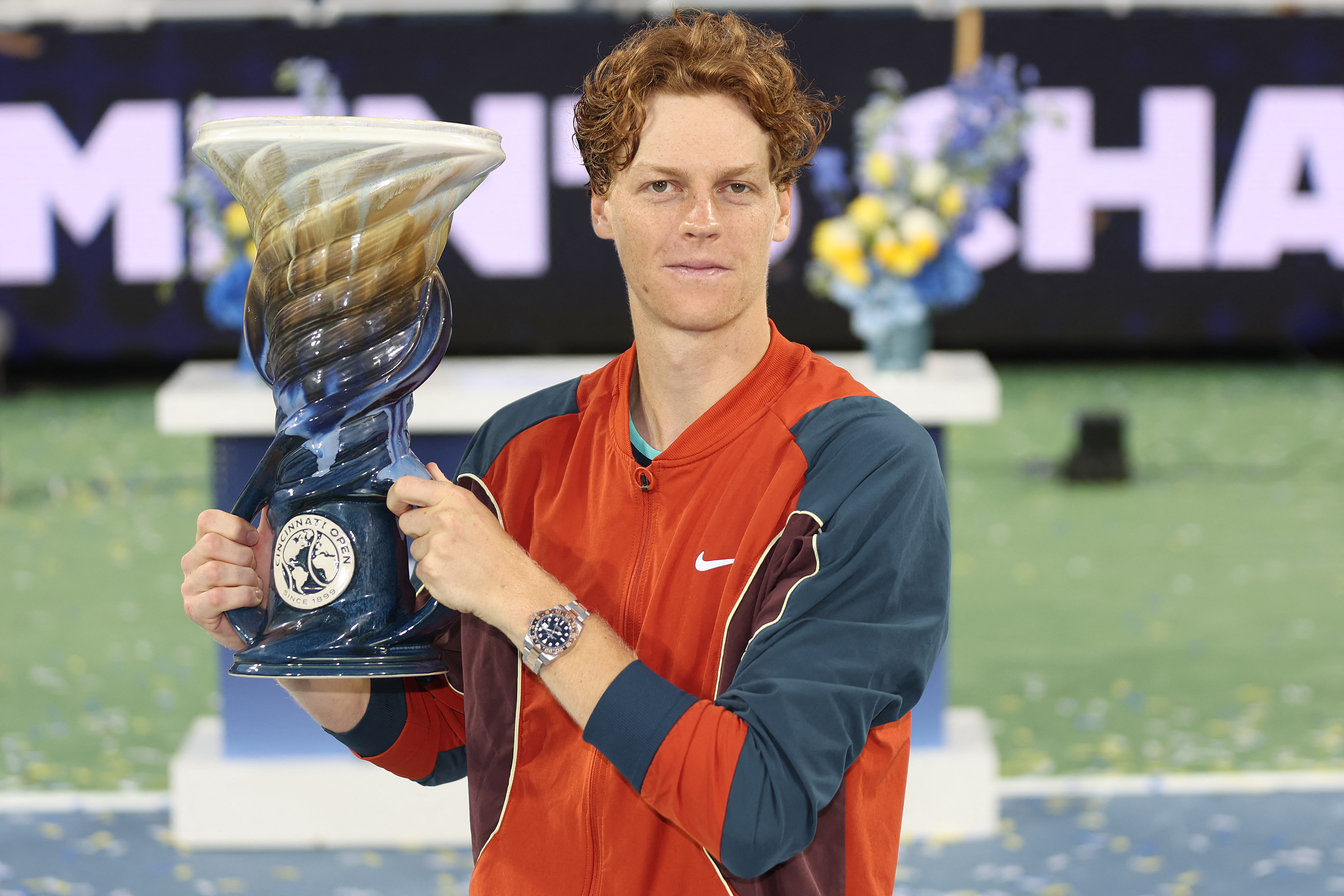 Tennis player holding trophy.