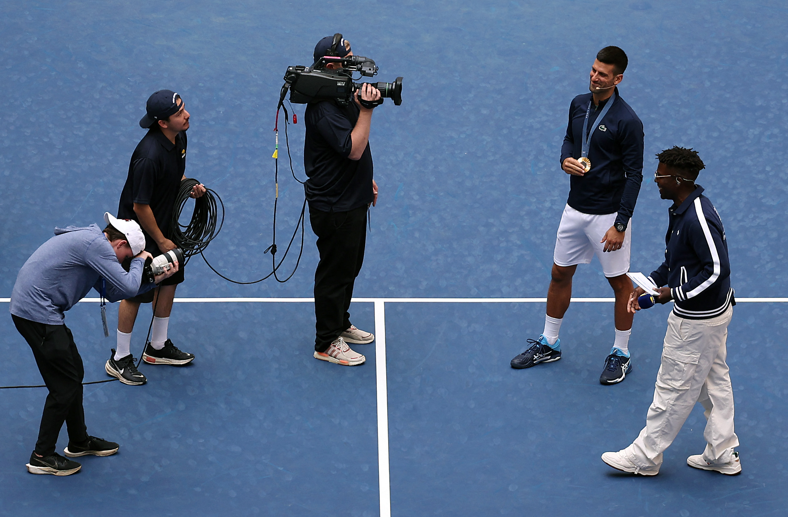 NEW YORK, NEW YORK - AUGUST 24: Novak Djokovic of Serbia shows off his gold medal while being introduced alongside Dude Perfect during Arthur Ashe Kid's Day ahead of the US Open at USTA Billie Jean King National Tennis Center on August 24, 2024 in New York City. Jamie Squire/Getty Images/AFP (Photo by JAMIE SQUIRE / GETTY IMAGES NORTH AMERICA / Getty Images via AFP)