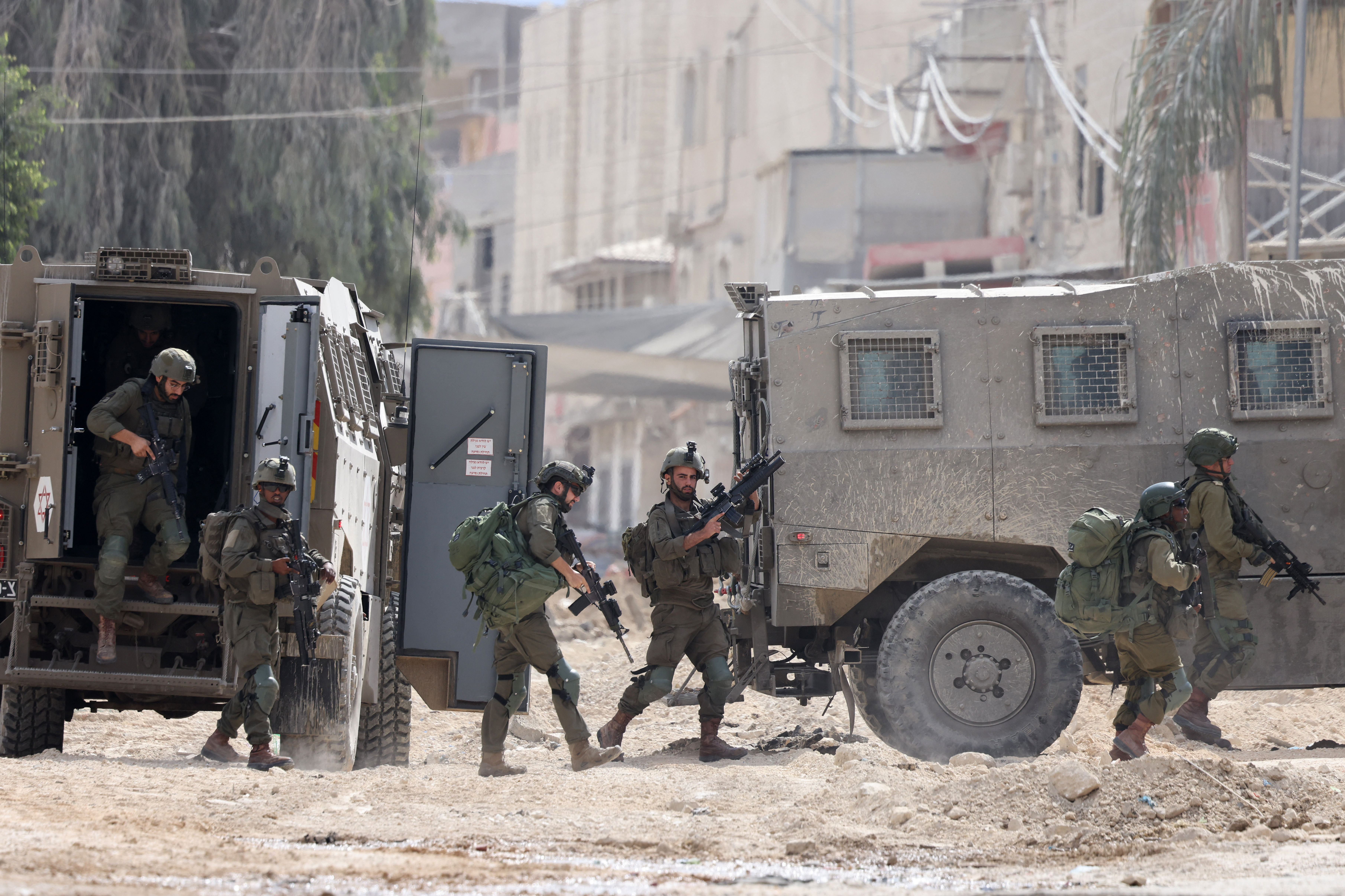 Israeli soldiers operate during a raid in the Nur Shams camp for Palestinian refugees near the city of Tulkarem in the Israeli-occupied West Bank on August 28, 2024. - At least 10 Palestinians were killed in Israeli raids and strikes in several towns in the north of the occupied West Bank, a spokesman for the Red Crescent said on August 28. The operation comes two days after Israel said it carried out an air strike on the West Bank that the Palestinian Authority reported killed five people. (Photo by JAAFAR ASHTIYEH / AFP)