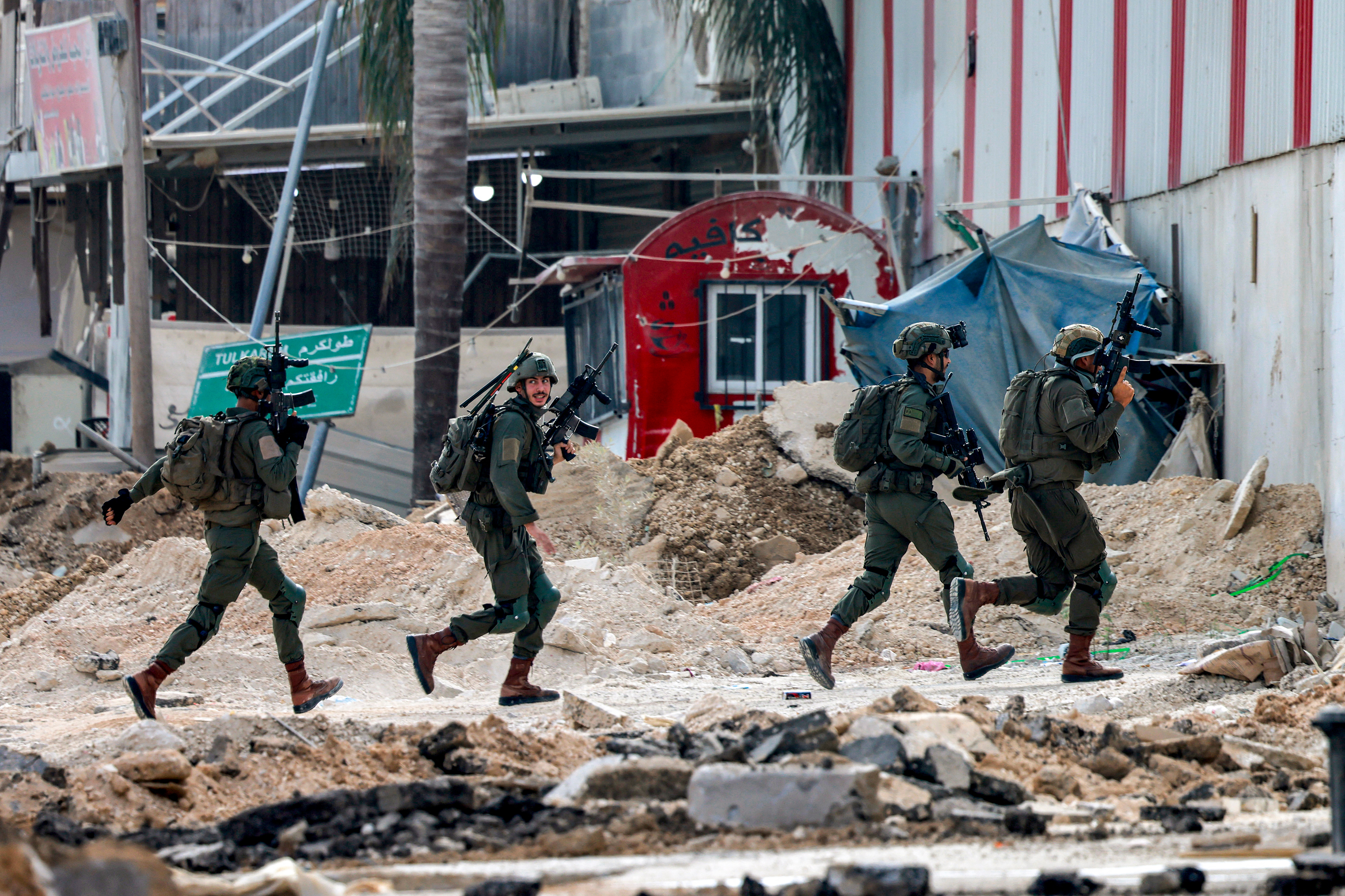 Israeli soldiers take position during an army operation in Tulkarm in the north of the occupied West Bank on August 29, 2024. - Israel on August 28 launched a large-scale operation in the occupied West Bank where the military said it killed Palestinian fighters, as the nearly 11-month-old Gaza war showed no signs of abating. (Photo by Jaafar ASHTIYEH / AFP)