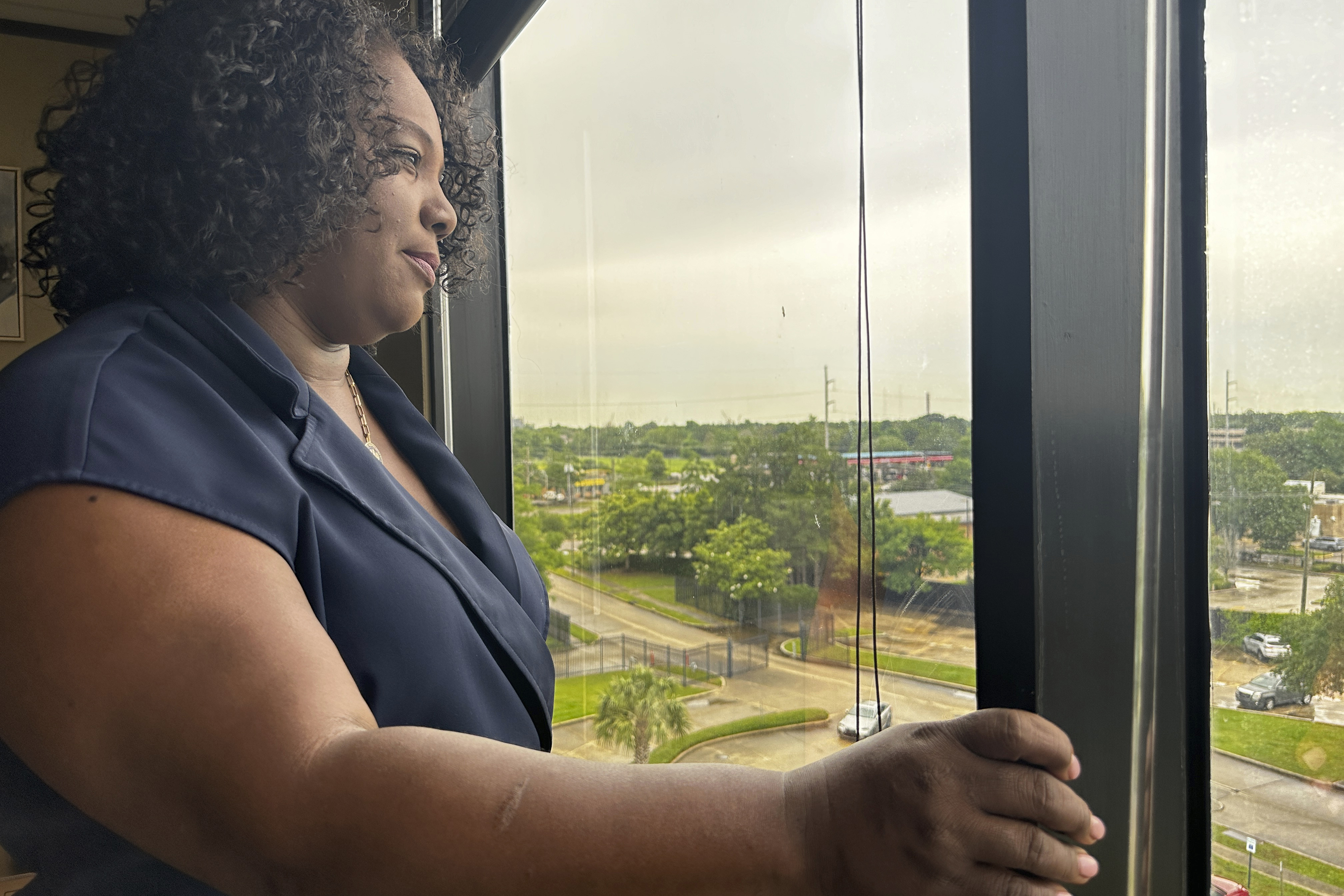 Delisha Boyd looks out an upper-story window in Louisiana.