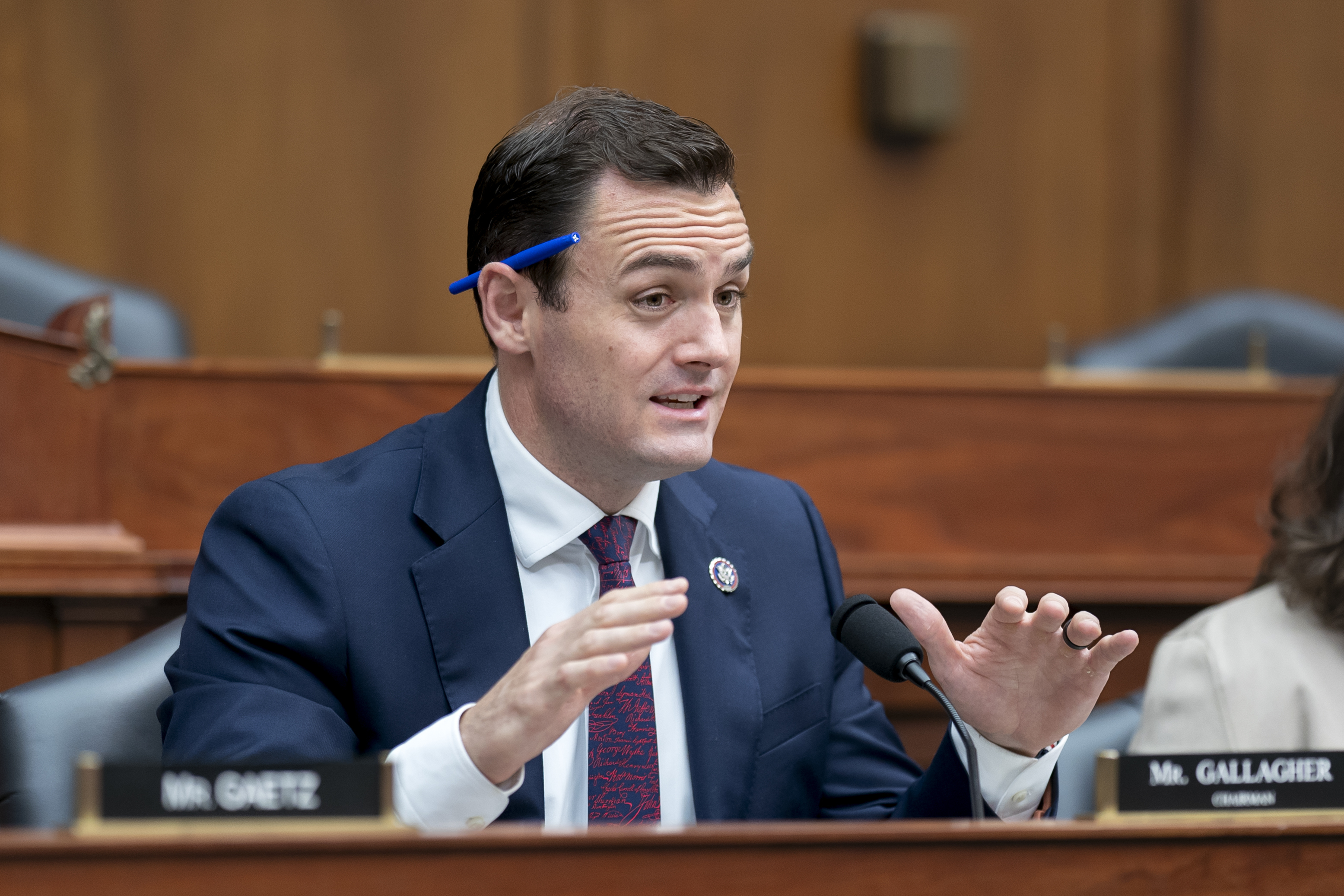 Mike Gallagher in a suit and tie at a panel hearing in Congress