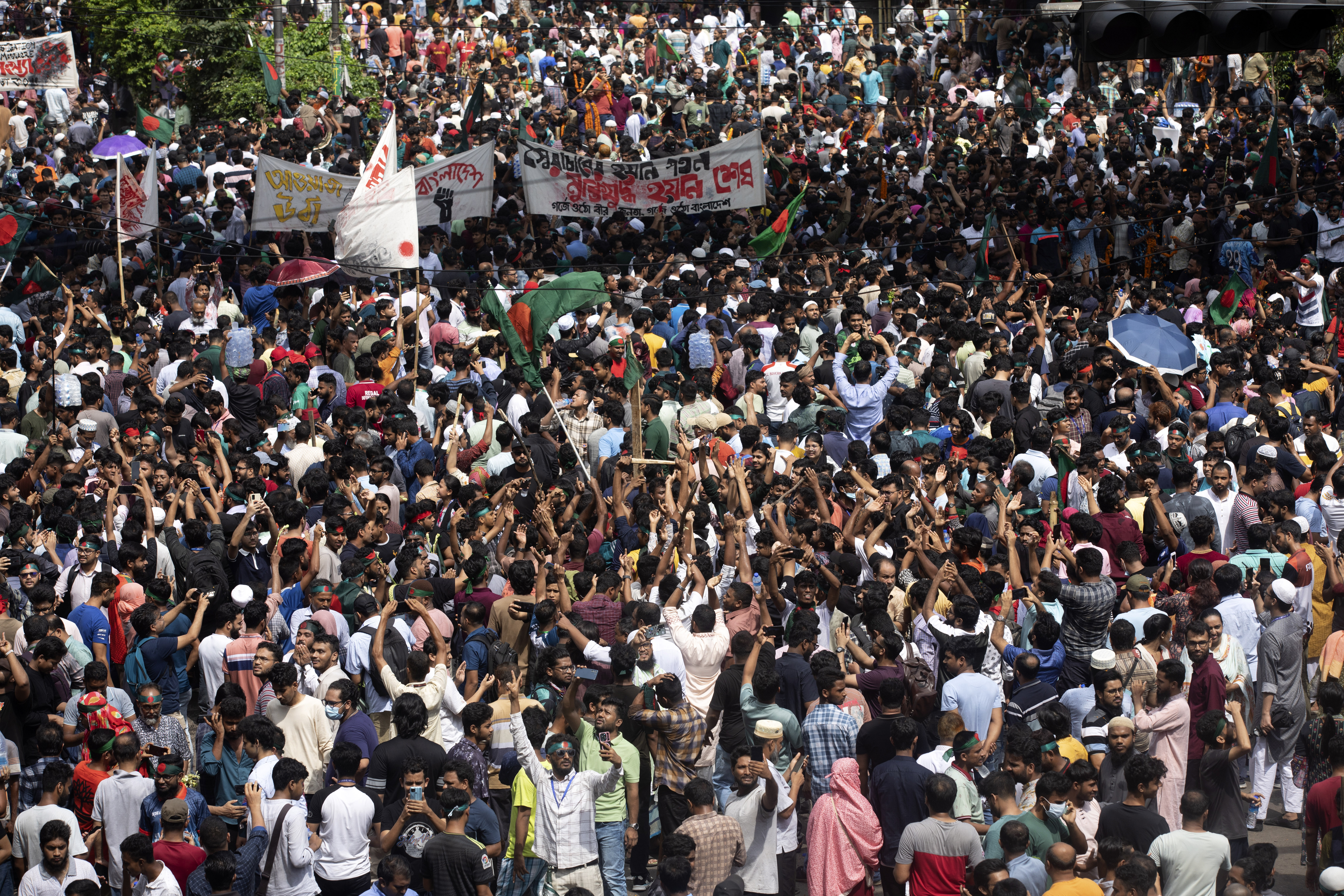 Protesters climb a public monument as they celebrate after getting the news of Prime Minister Sheikh Hasina's resignation, in Dhaka, Bangladesh