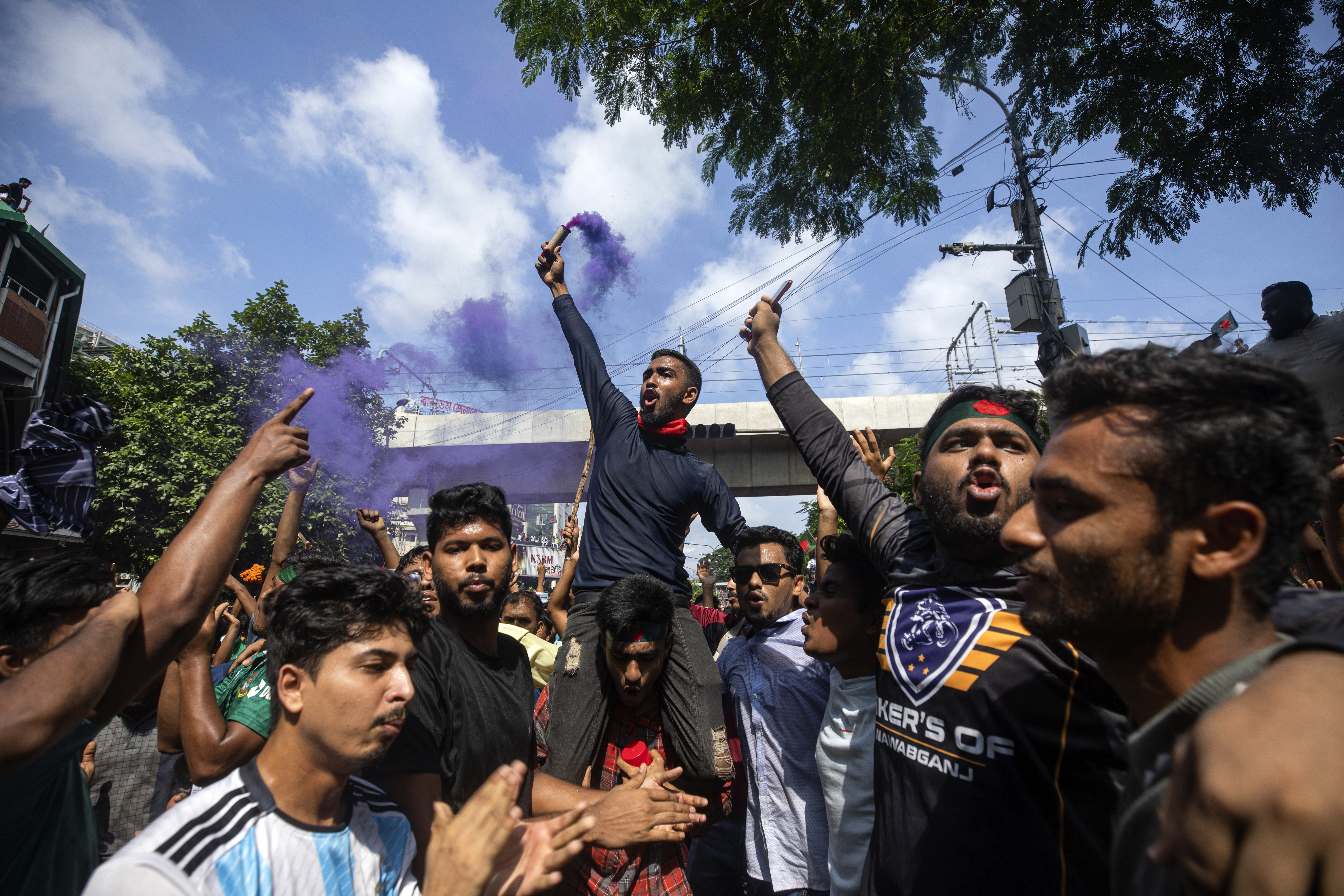 Protesters climb a public monument as they celebrate after getting the news of Prime Minister Sheikh Hasina's resignation, in Dhaka, Bangladesh