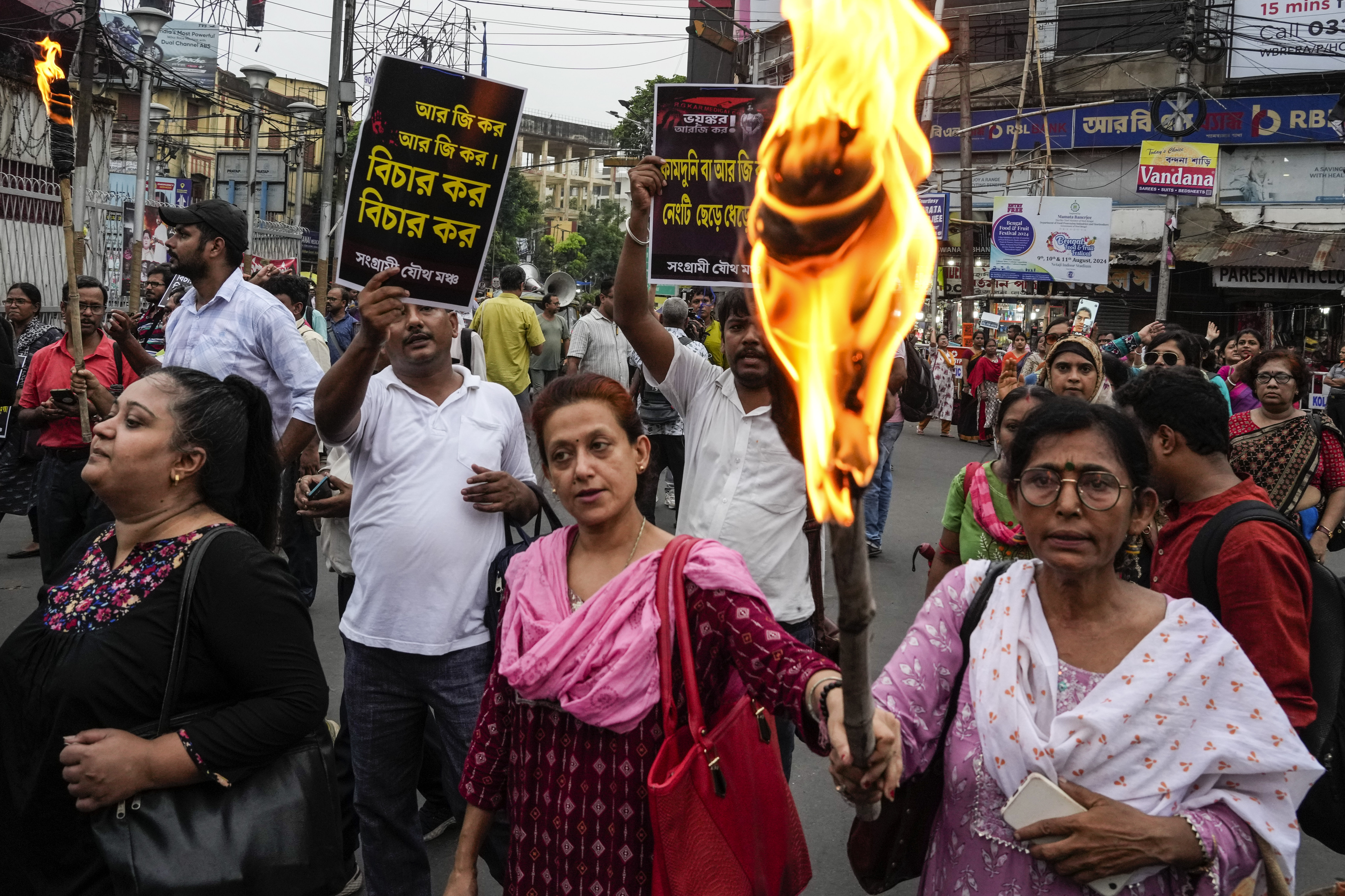 Following a murder of a 31 year old post-graduate trainee (PGT) doctor by rape and torture inside a government hospital, activists of different humanitarian and political organisations and medical professionals participate in a rally with posters and torches demanding adequate intervention of the ruling government and exemplary punishment of the culprits, in Kolkata, India, Tuesday, Aug. 13, 2024.